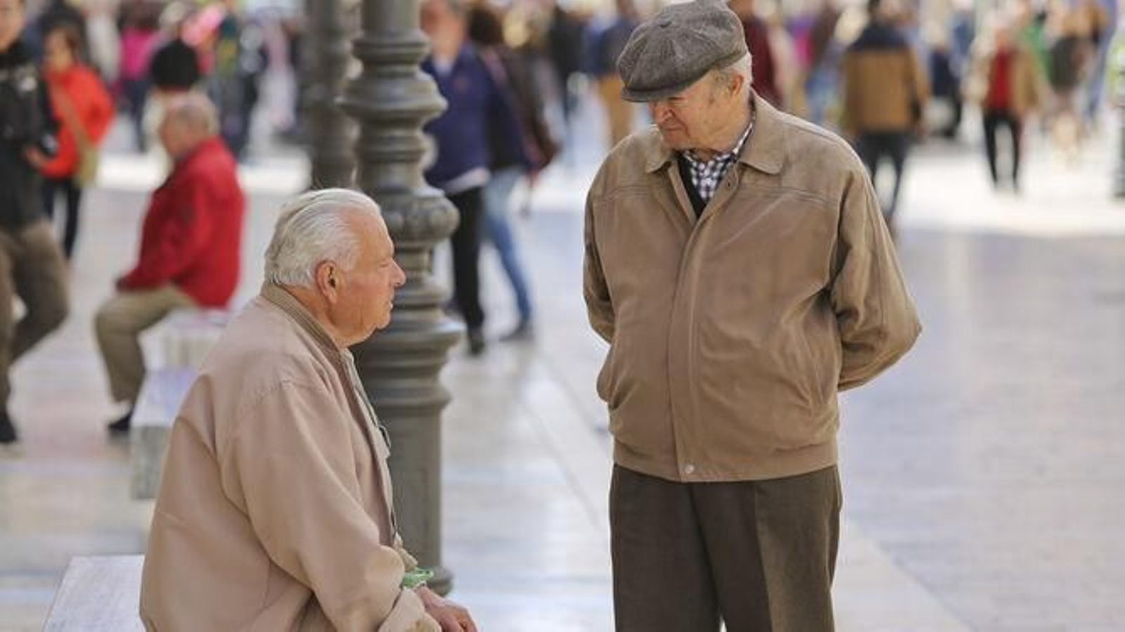 Dos jubilados dialogan en una vía pública