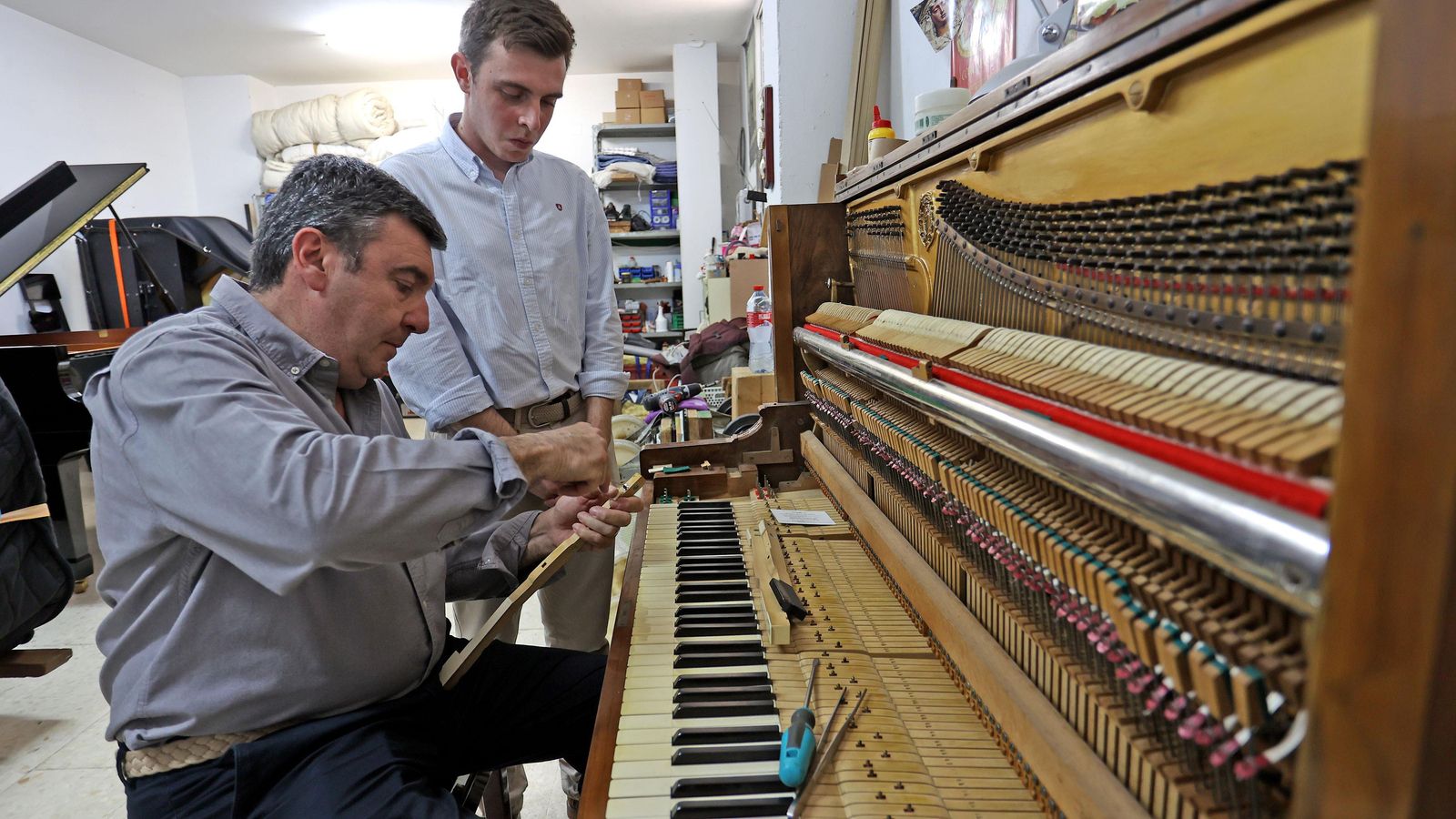 José y su hijo, restaurando un piano de hace un siglo.