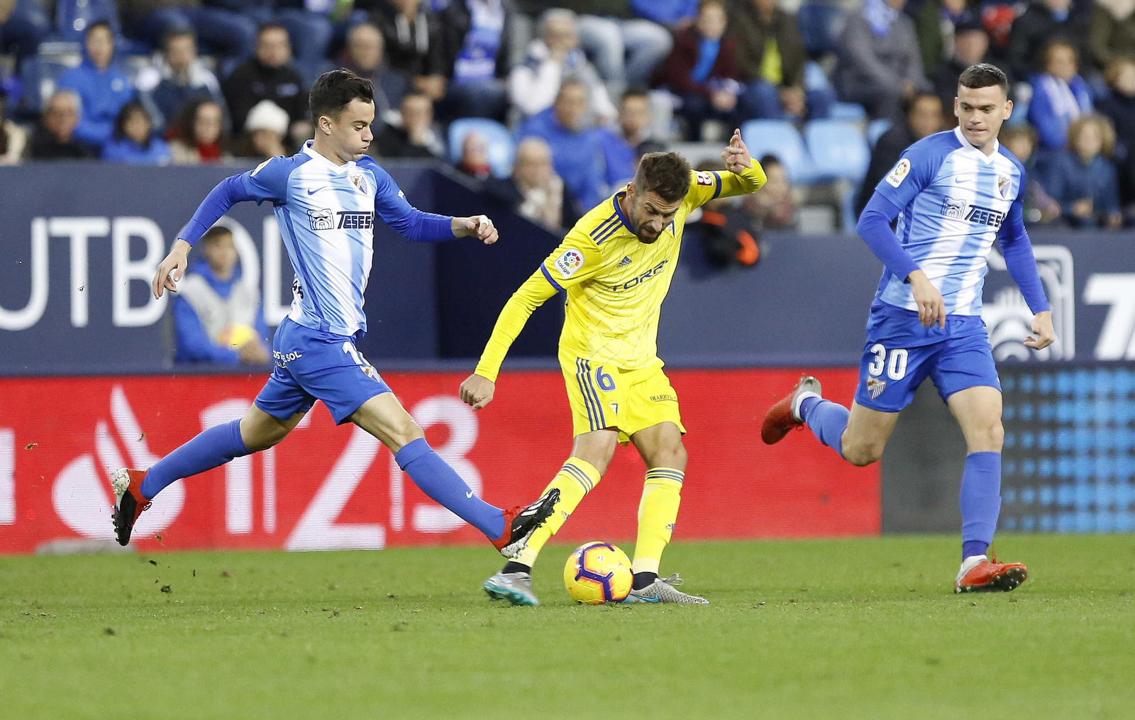 José Mari intenta golpear el balón estorbado por Juanpi.