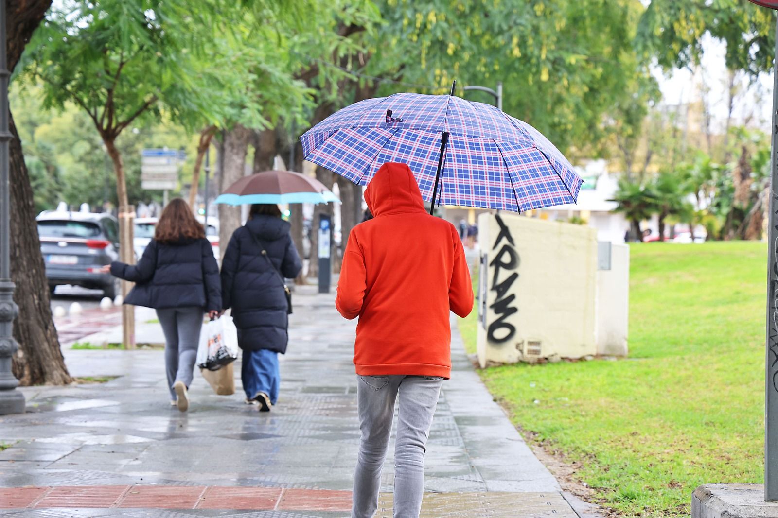 Una persona se refugia de la lluvia en Huelva.