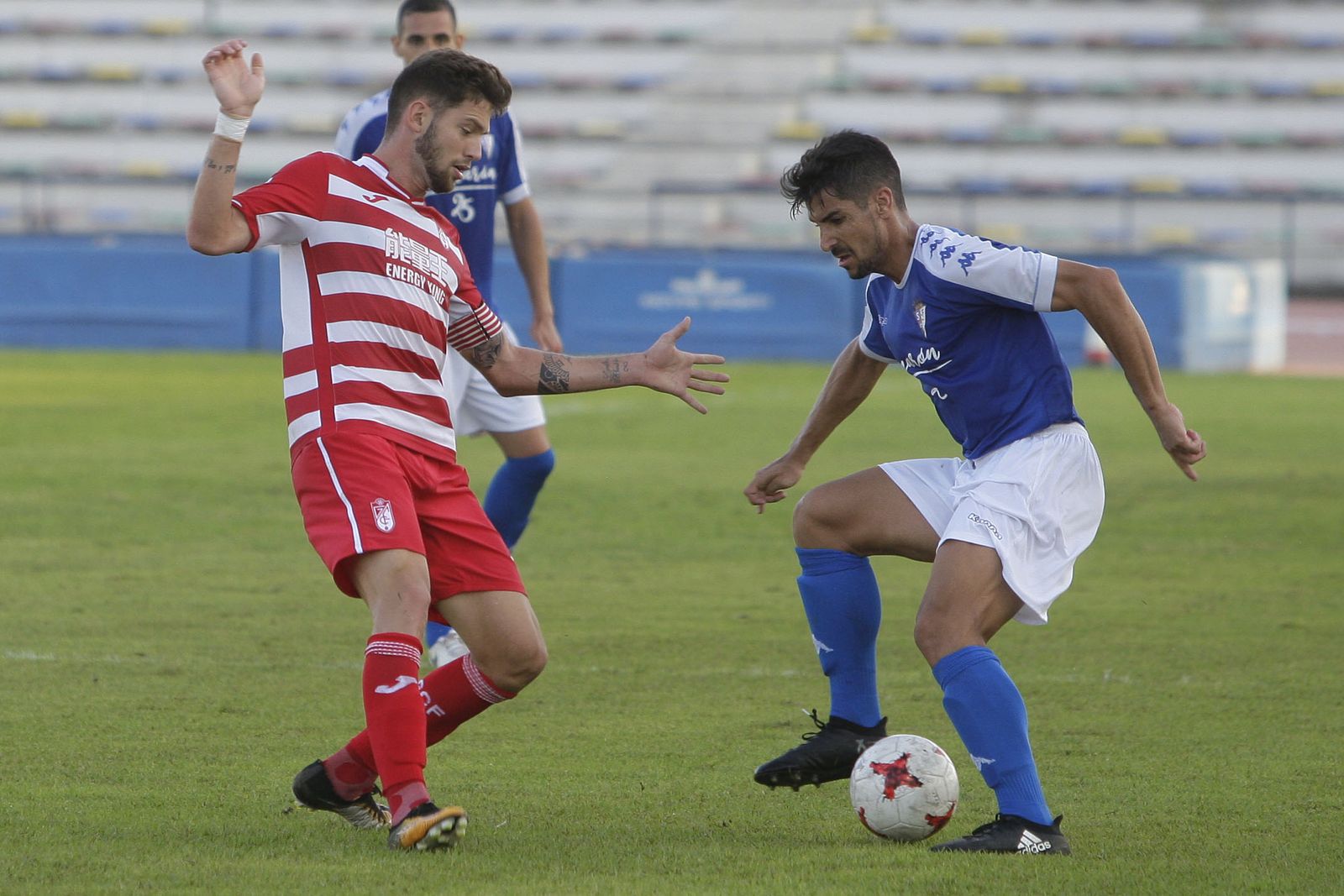 Pugna por el balón entre un jugador de cada equipo durante el choque de ayer en San Fernando.