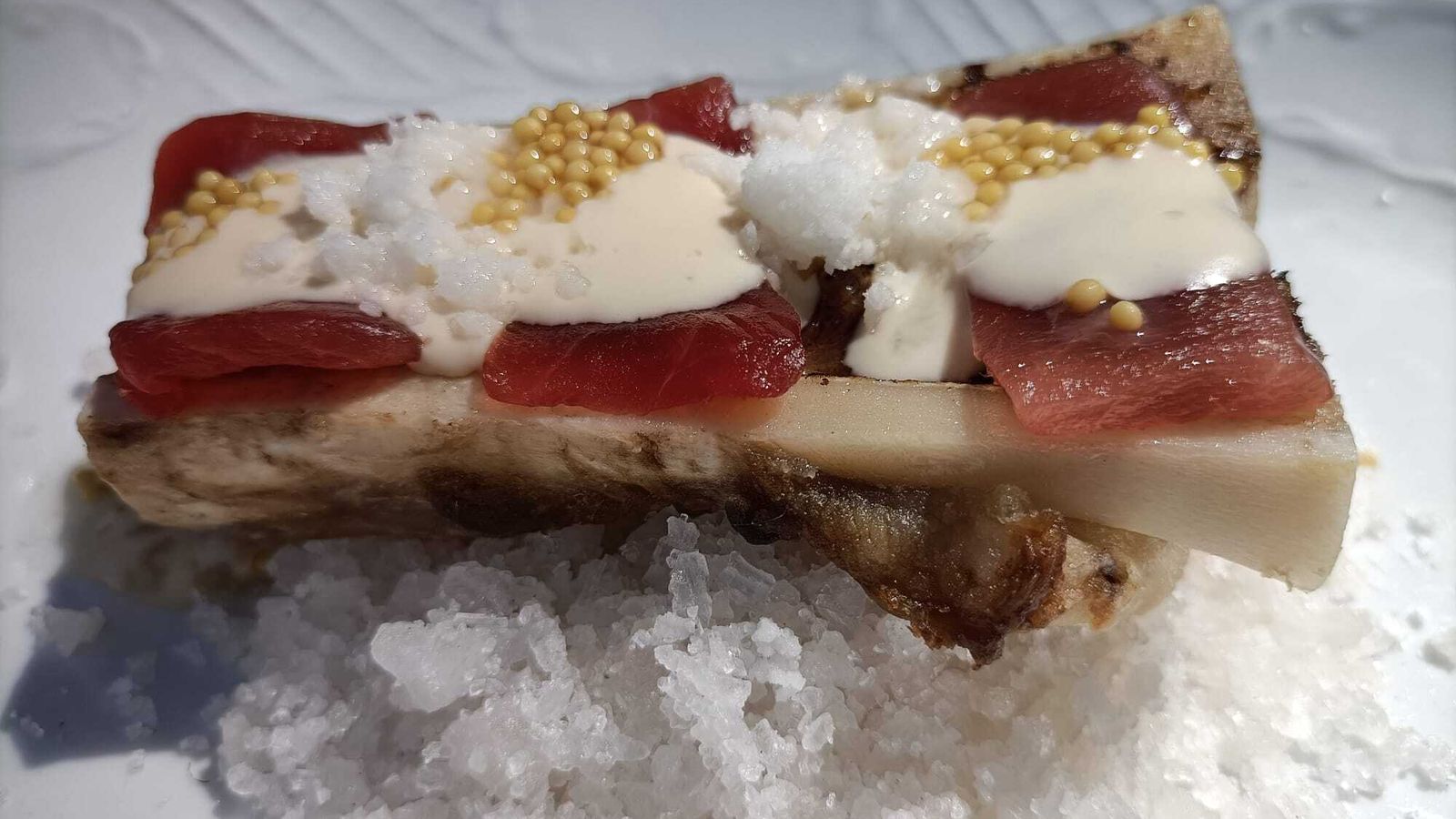 Tuétano de vaca asado picoso, láminas de atún, semillas de mostaza y almendra y Alhambra Reserva Esencia Citra IPA