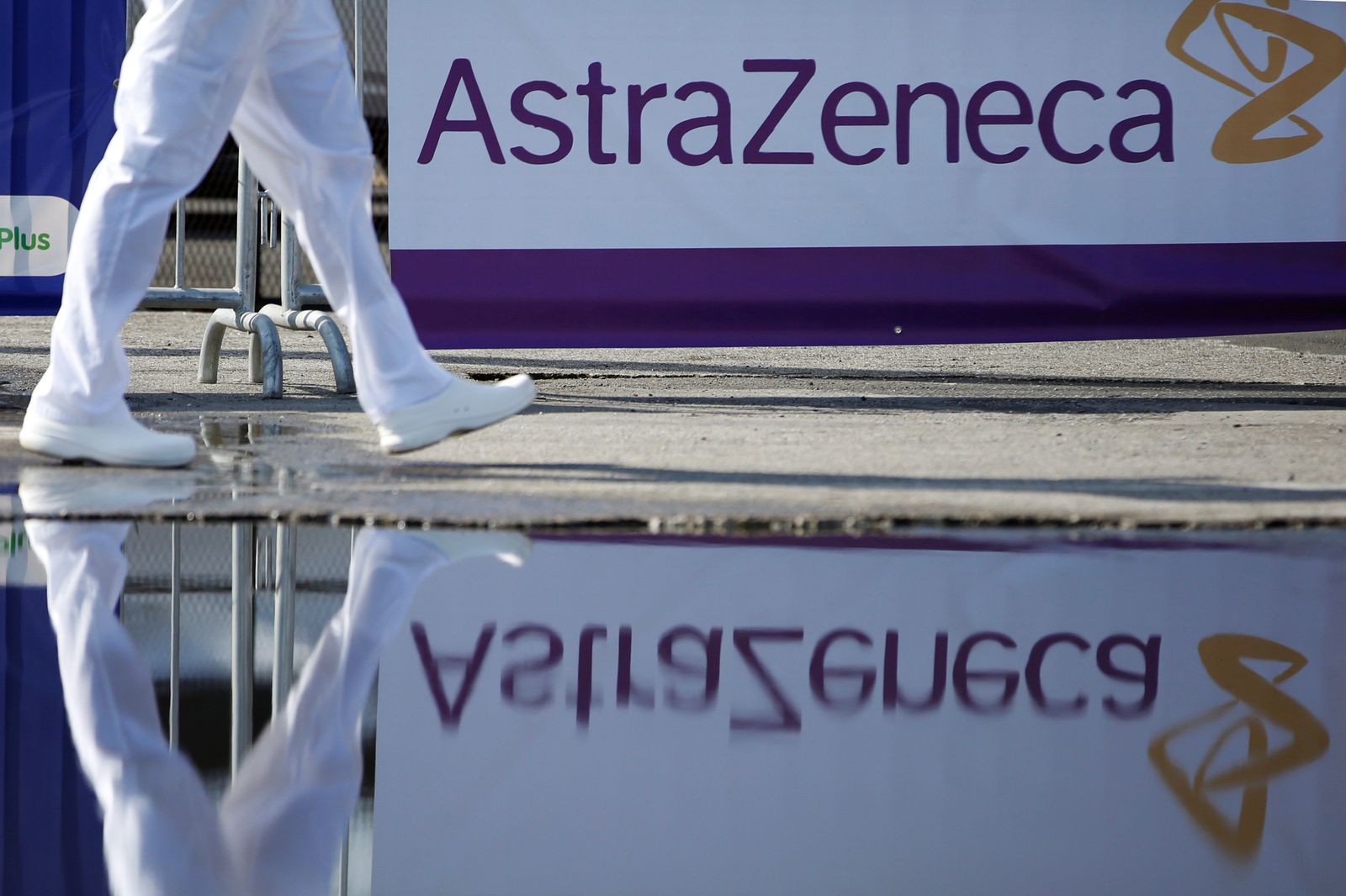 Un sanitario pasa ante un cartel de AstraZeneca.