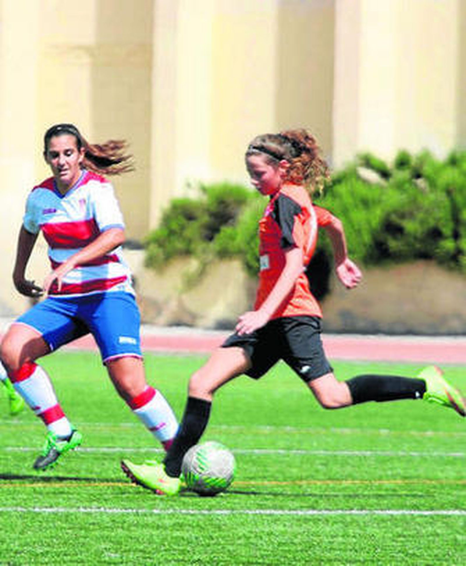 Una jugadora de El Naranjo trata de centrar en presencia de una rival.