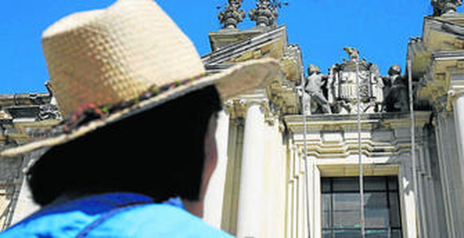 Una persona contempla el escudo de la antigua Puerta de Ciencias, en el Rectorado.