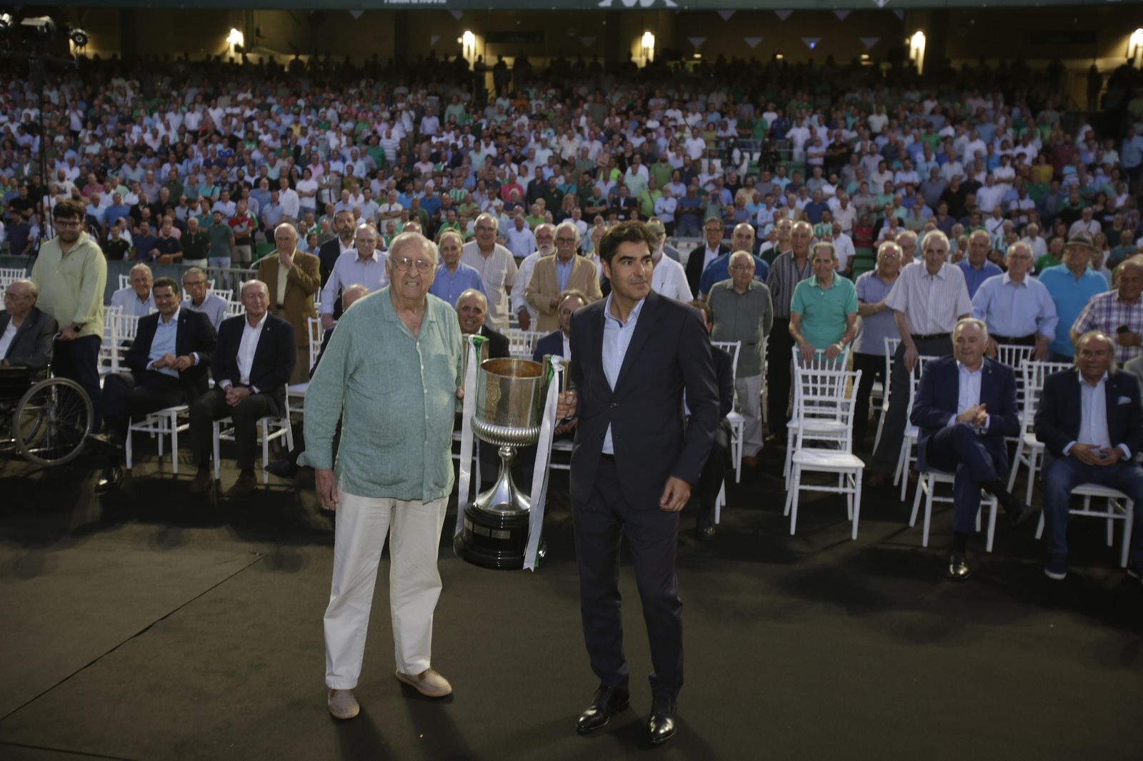 Joaquín Real, socio número 5 del Betis, aguanta la Copa del Rey con el presidente, Ángel Haro, en la foto de familia del acto celebrado en el Villamarín.