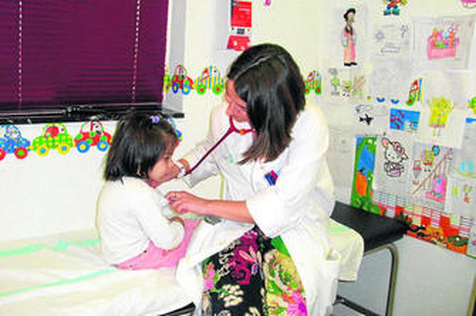 Una pediatra almeriense atiende a una chica enferma en su consulta.