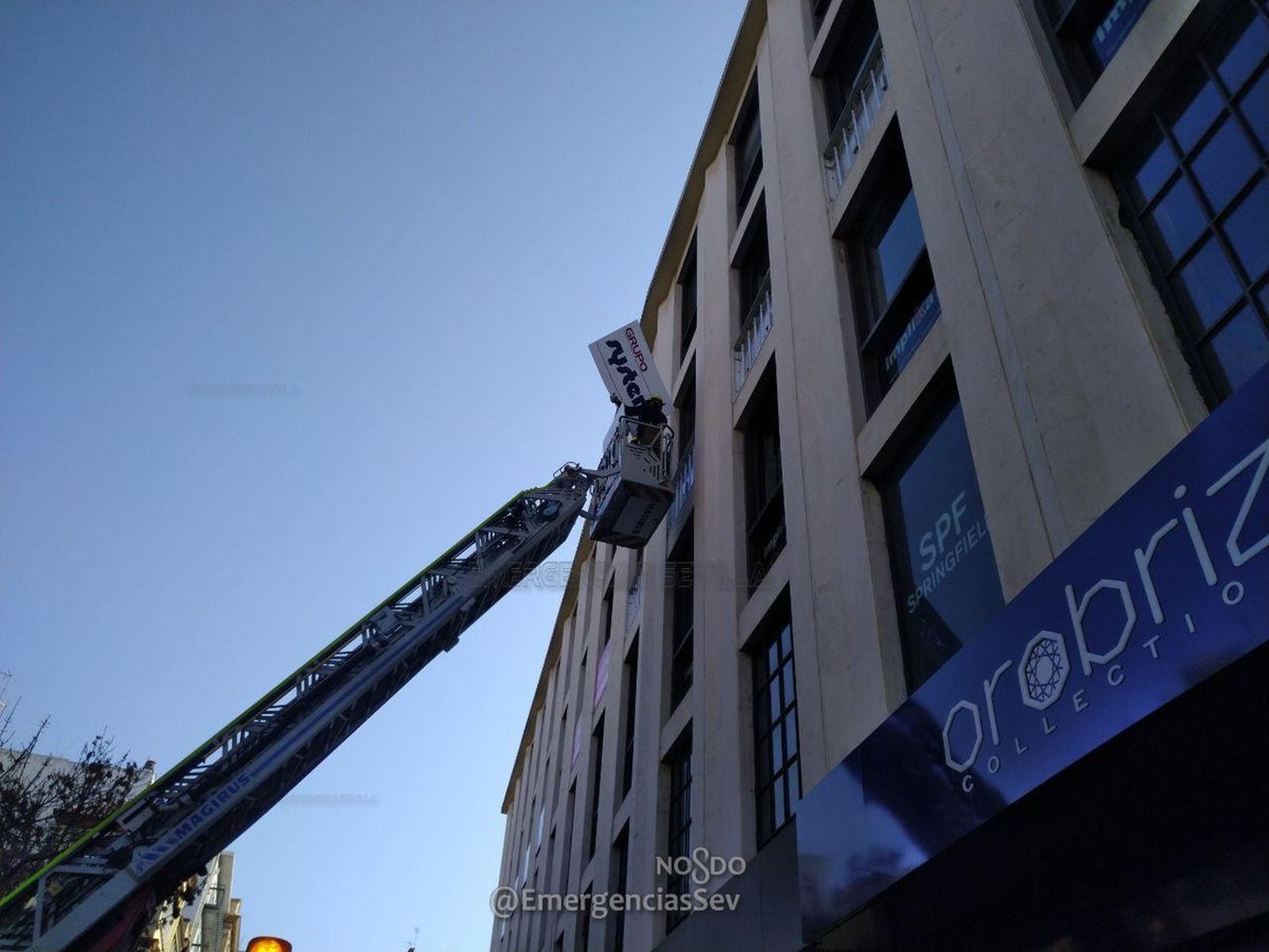 Los bomberos retiran los carteles con riesgo de caída en la Plaza del Duque.