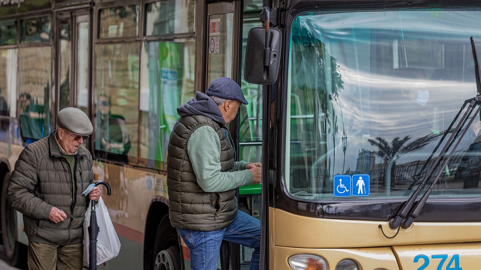 Dos ciudadanos tomando el autobús en Cádiz.