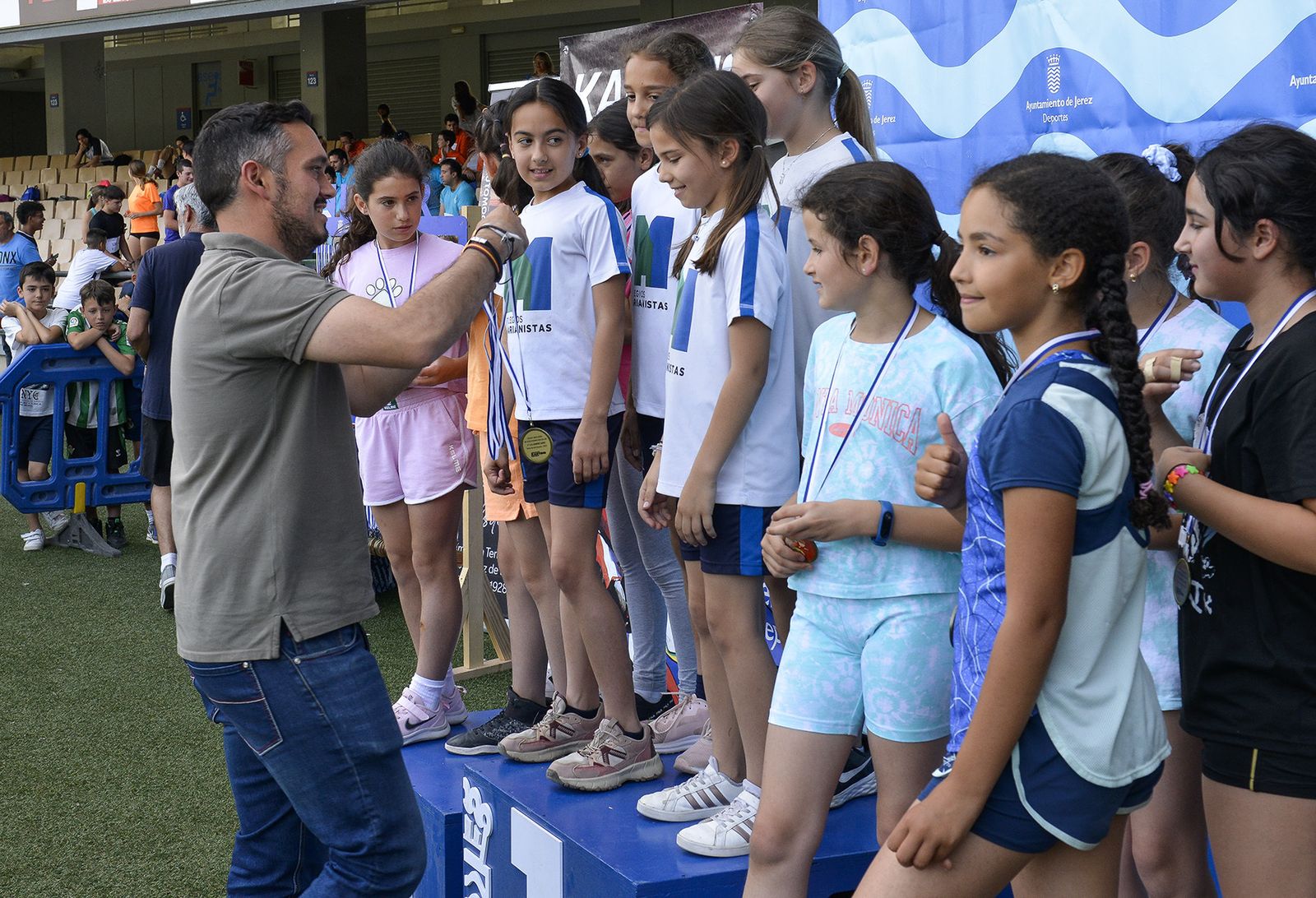Jesús Alba cuelga las medallas a la niñas ganadoras de una de las pruebas.