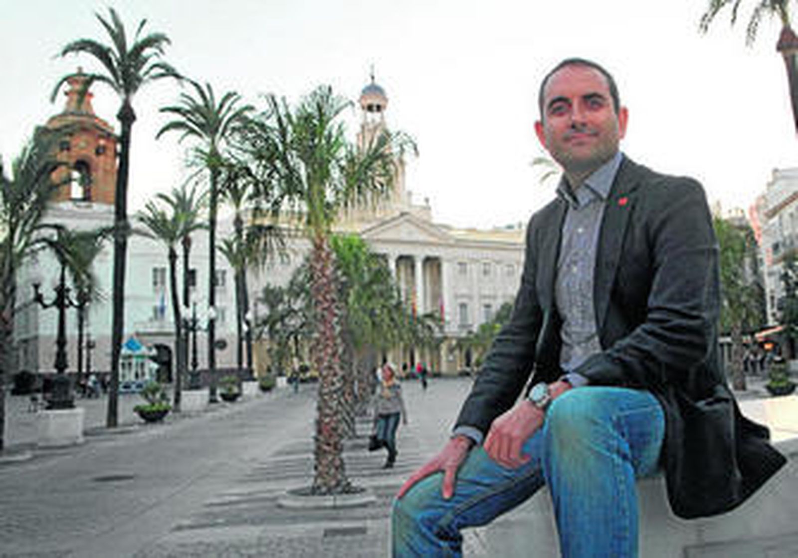José David Sánchez de Medina posa en la estatua de Moret con la fachada del Ayuntamiento al fondo.