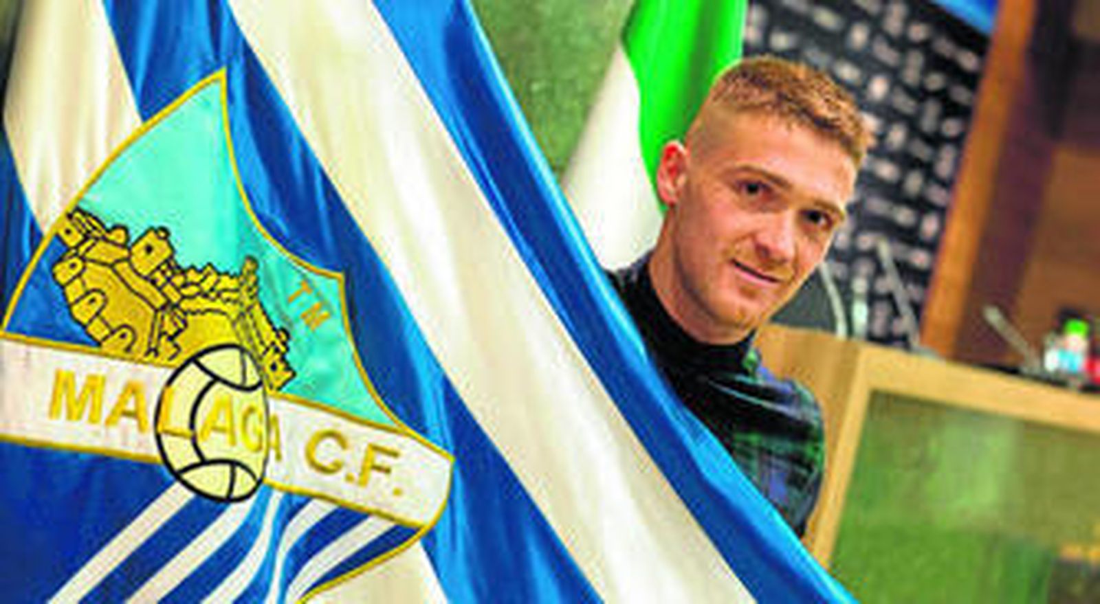 Antunes posa con una bandera del club tras firmar su renovación con el Málaga.