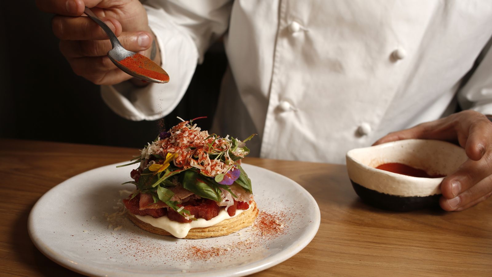 Finalización del plato con polvo de tomate.