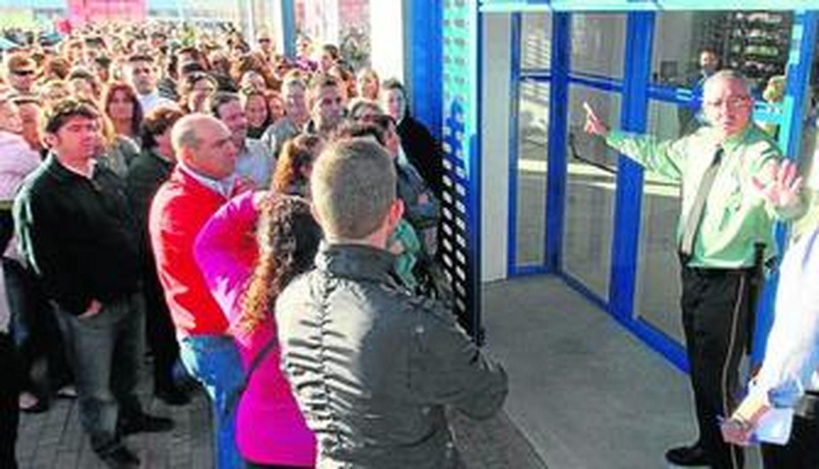 El vigilante de seguridad de GMI, ayer, con serios problemas para frenar la avalancha de público a la tienda de Luz Shopping.