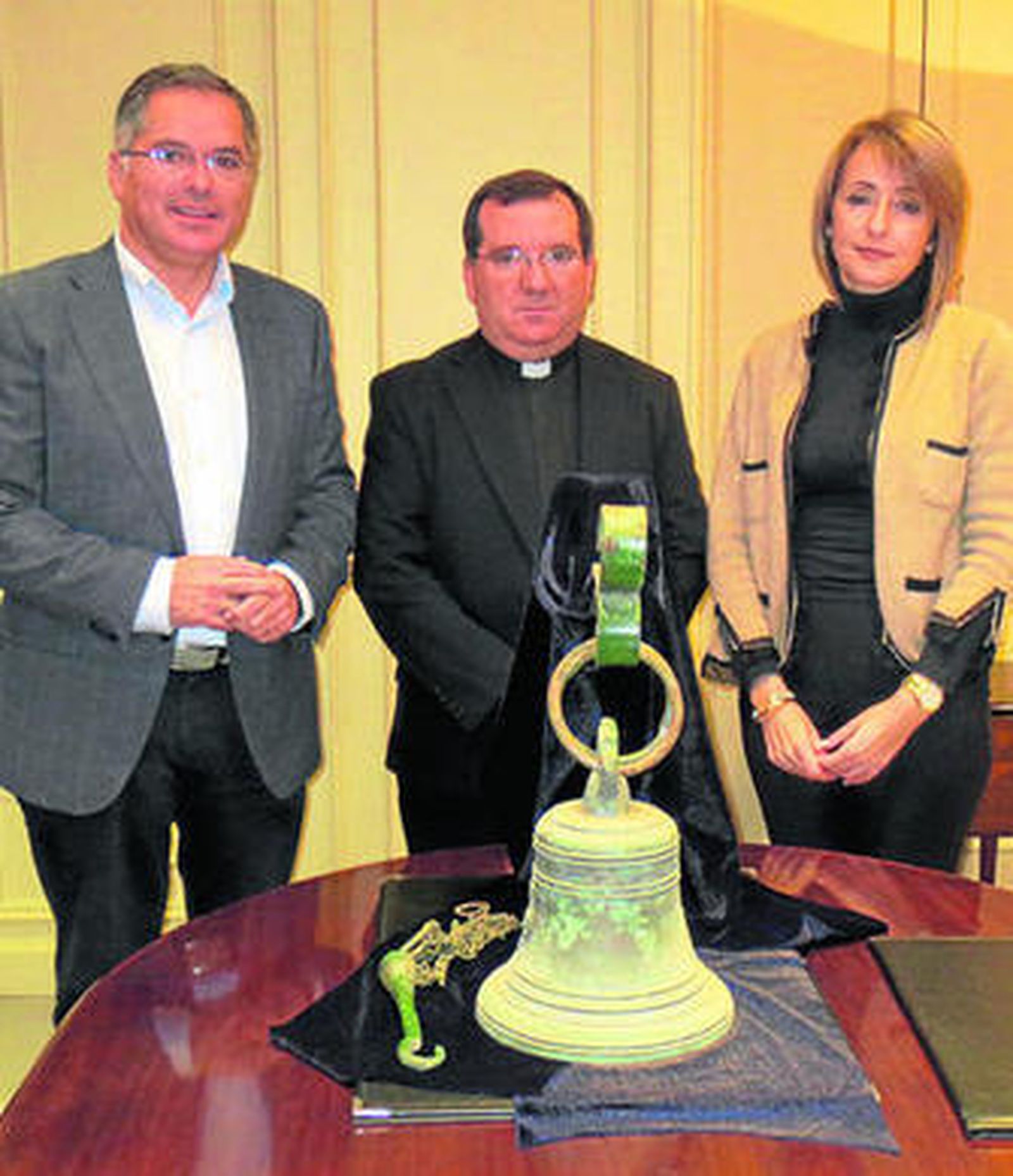 Jacinto Muñoz, José Luis Palacio y Pilar Pintor posan ayer junto a la campana.