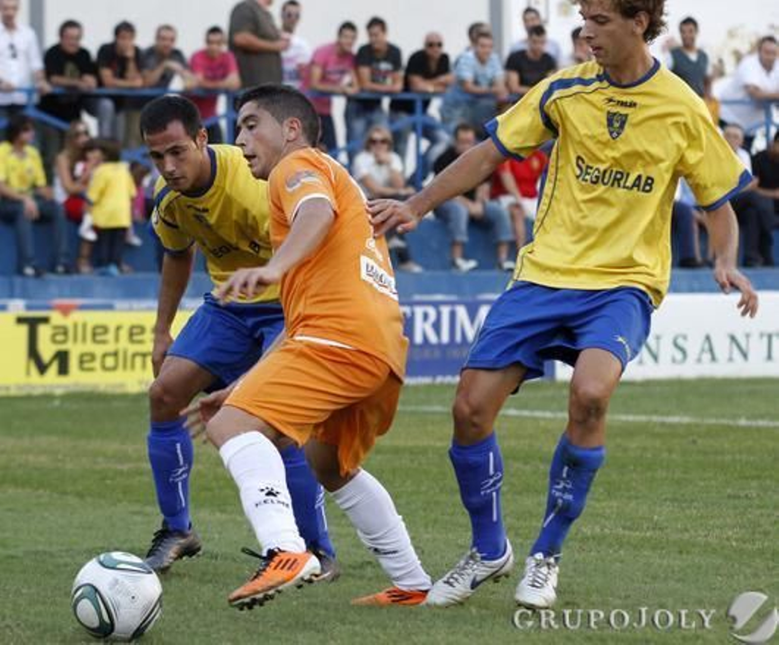 El canterano cadista intenta conservar la pelota entre dos contrarios.

Foto: LOF