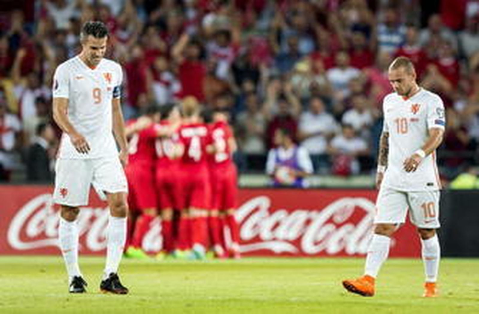 Van Persie y Sneijder, desolados mientras los jugadores de Turquía celebran uno de sus goles.