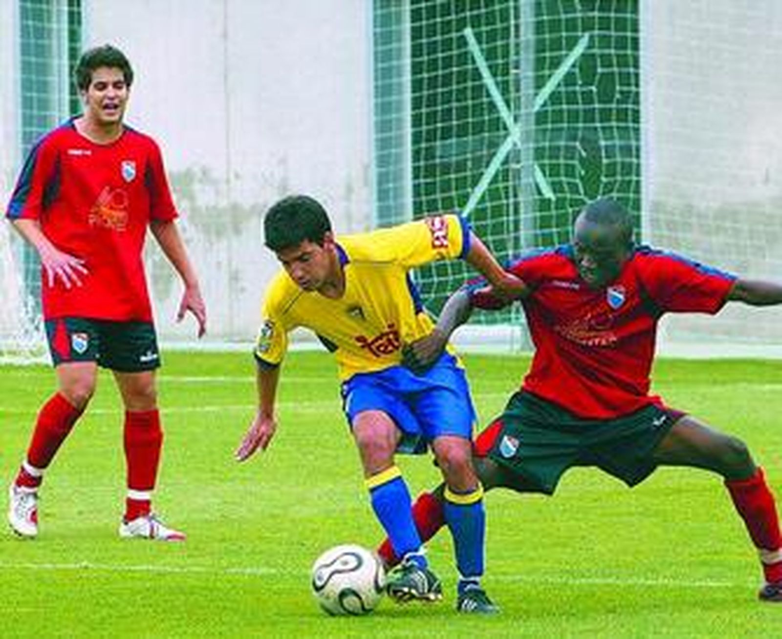 El delantero del Cádiz B Bienve protege el balón ante el acoso del defensa rival Djily.