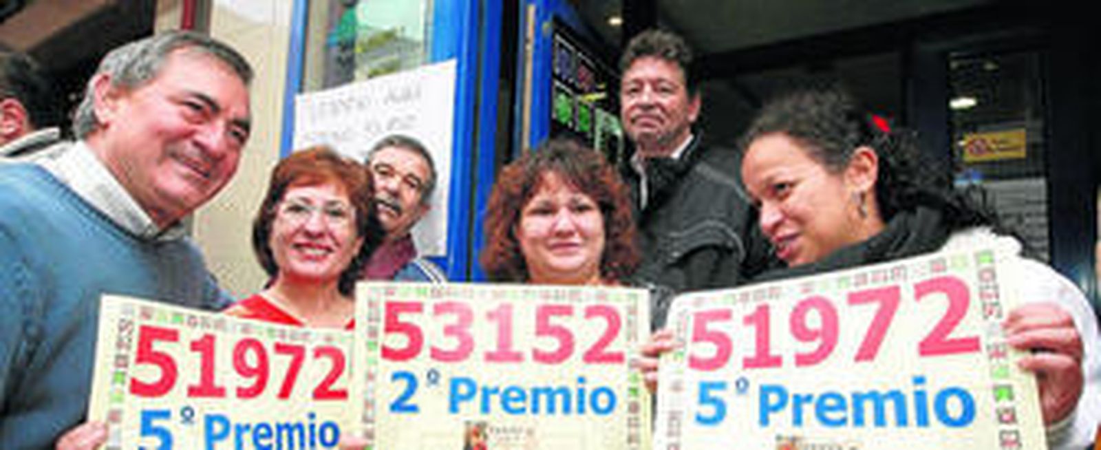 Conchi Jiménez, propietaria de la administración de Getafe que repartió el segundo y quinto premio, muestra los dos números agraciados.