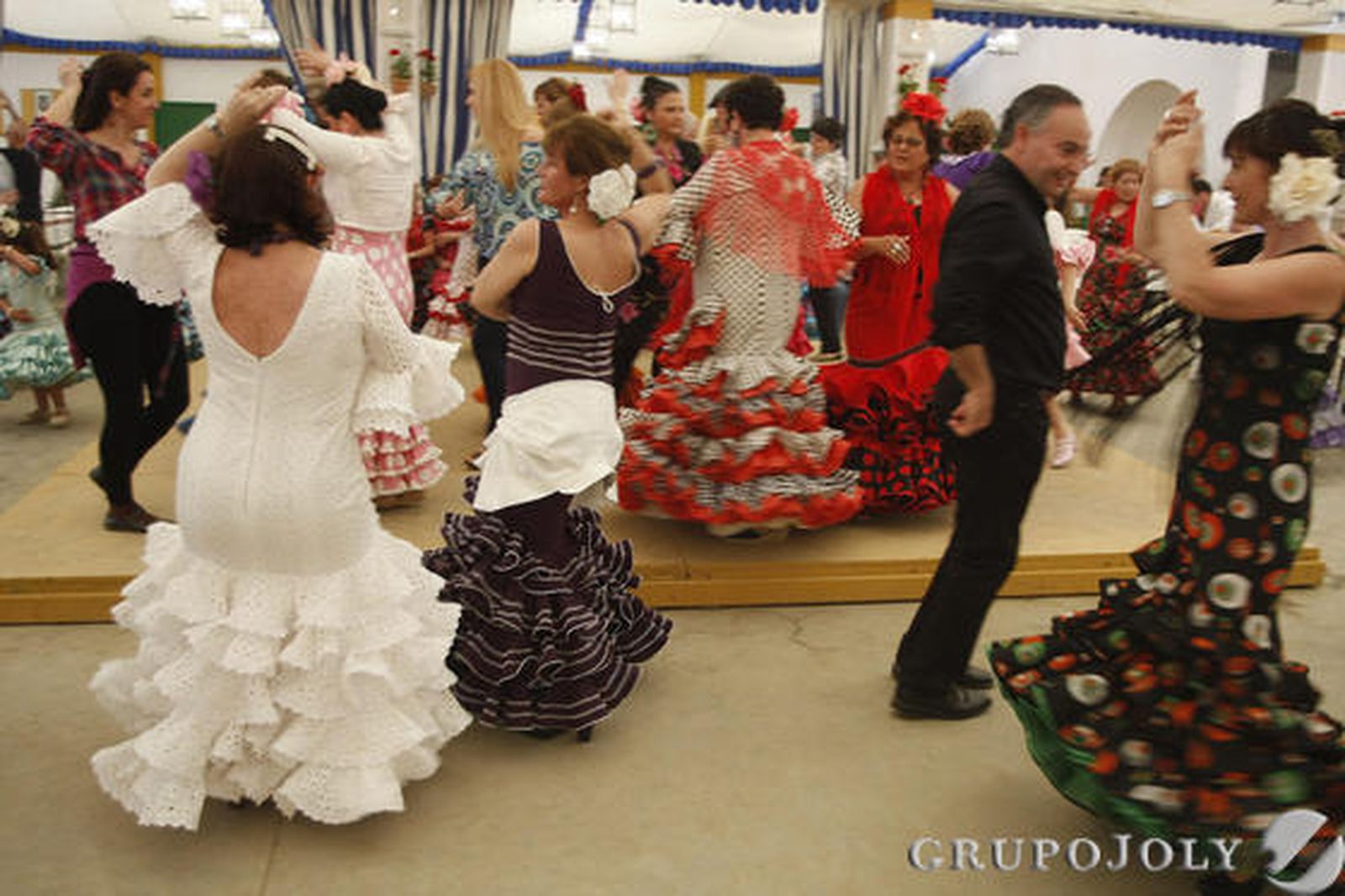 Un grupo baila en una de las casetas del recinto ferial de Las Banderas. La buena afluencia de público está siendo una de las notas dominantes de esta edición. /Andrés Mora