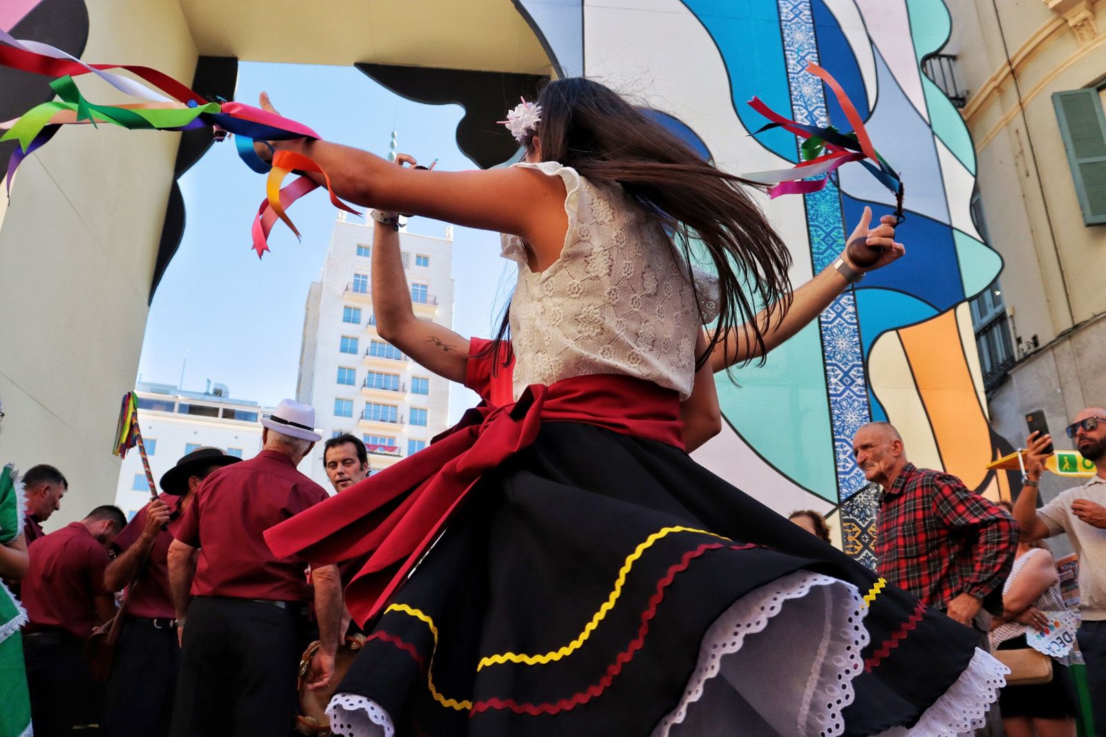 Una joven baila verdiales bajo la portada de la calle Larios.