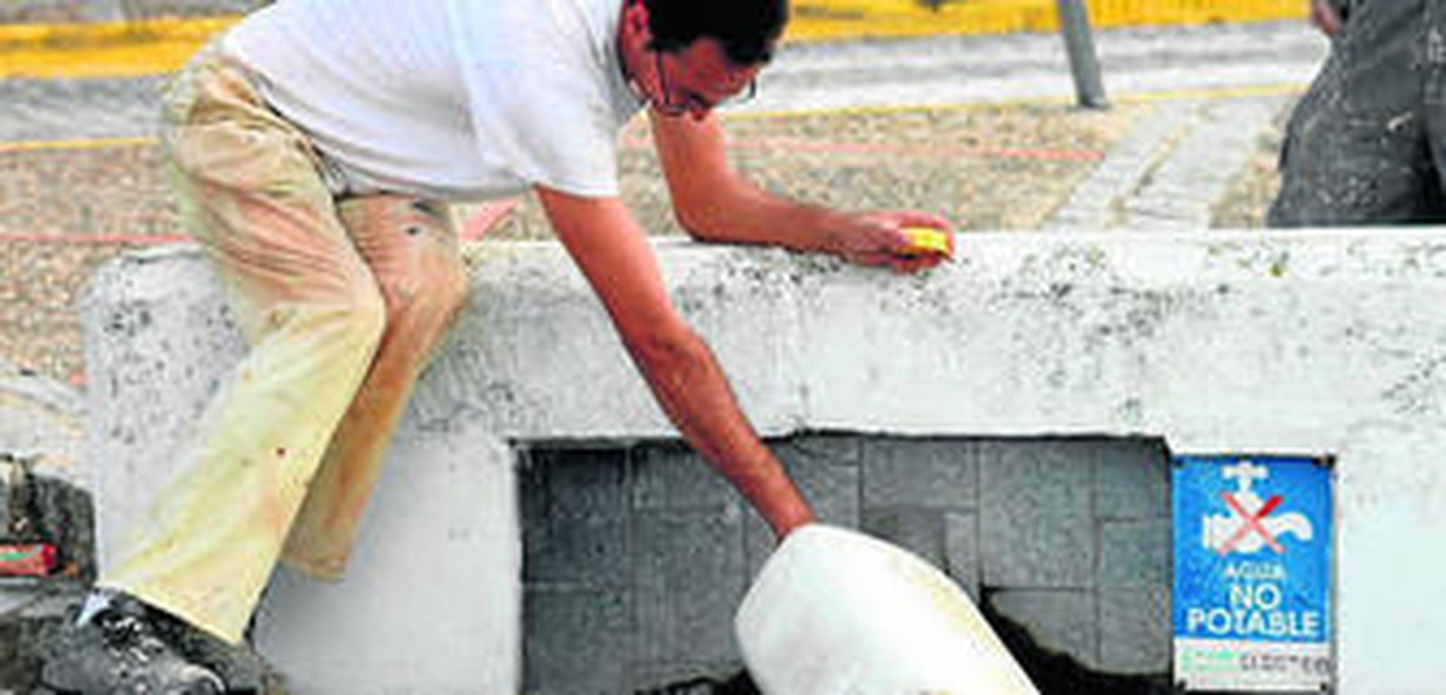 Un vecino de Medina llena una garrafa en una de las fuentes públicas.