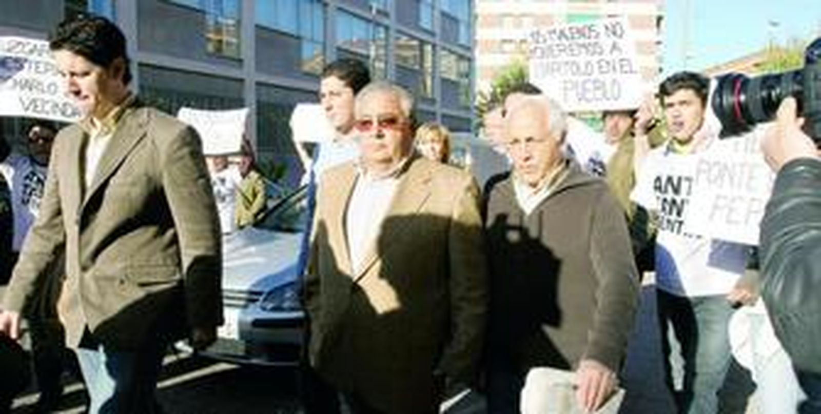 El procesado, B. G. C., en el centro (con gafas de sol), llega a los juzgados abucheado por un grupo de vecinos de la localidad de Posadas.