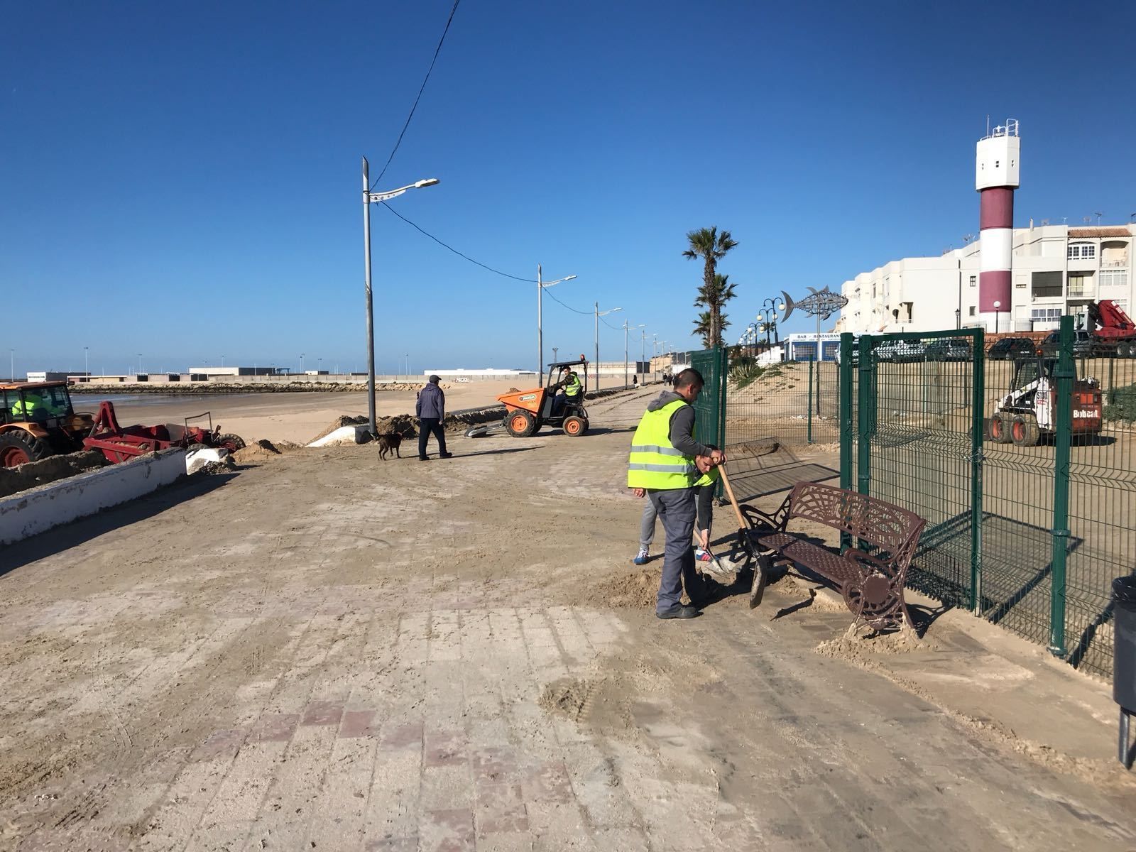 Trabajadores limpiando la playa.
