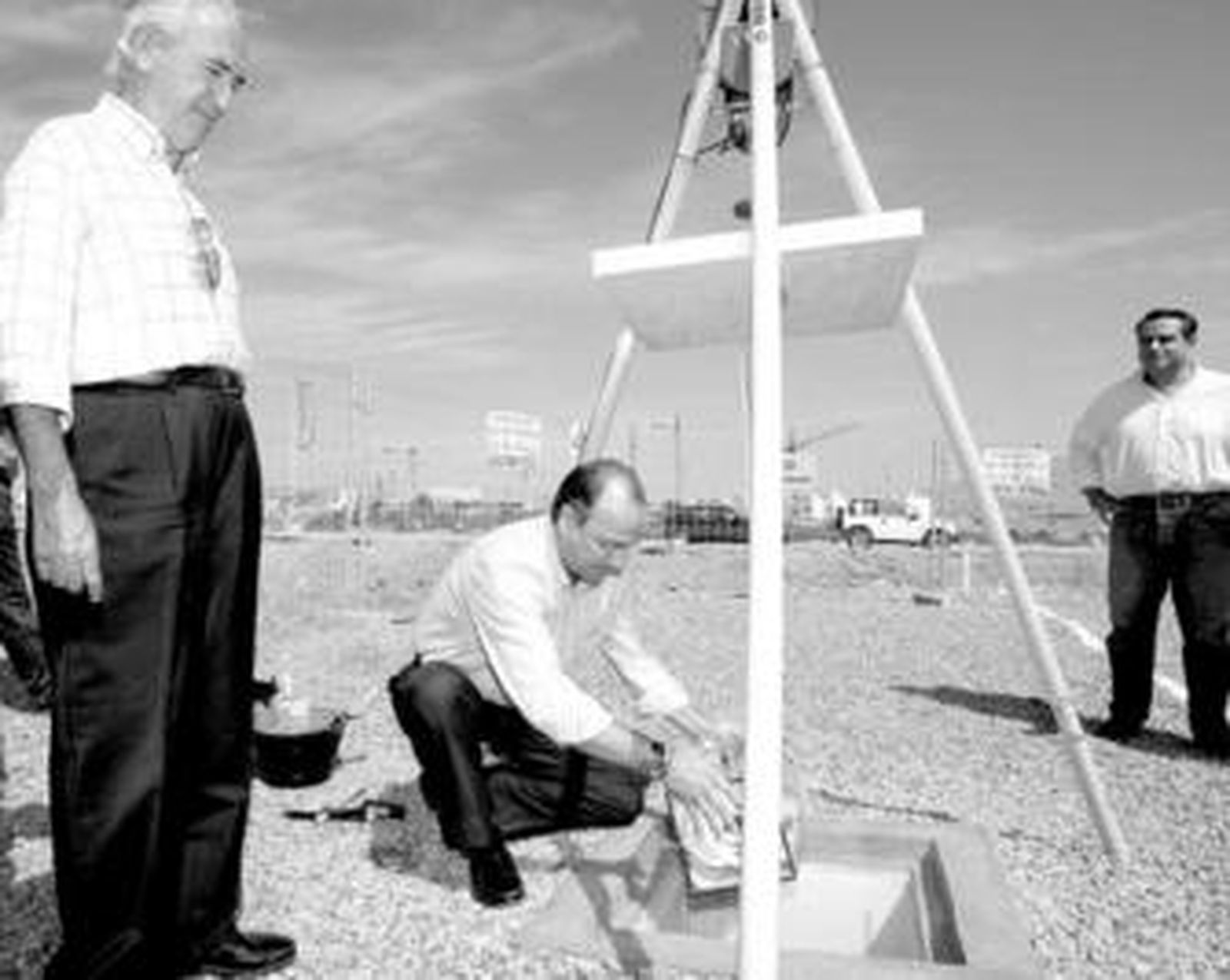 El alcalde introduce el cofre con periódicos del día y monedas ante la mirada de Juan Megino.