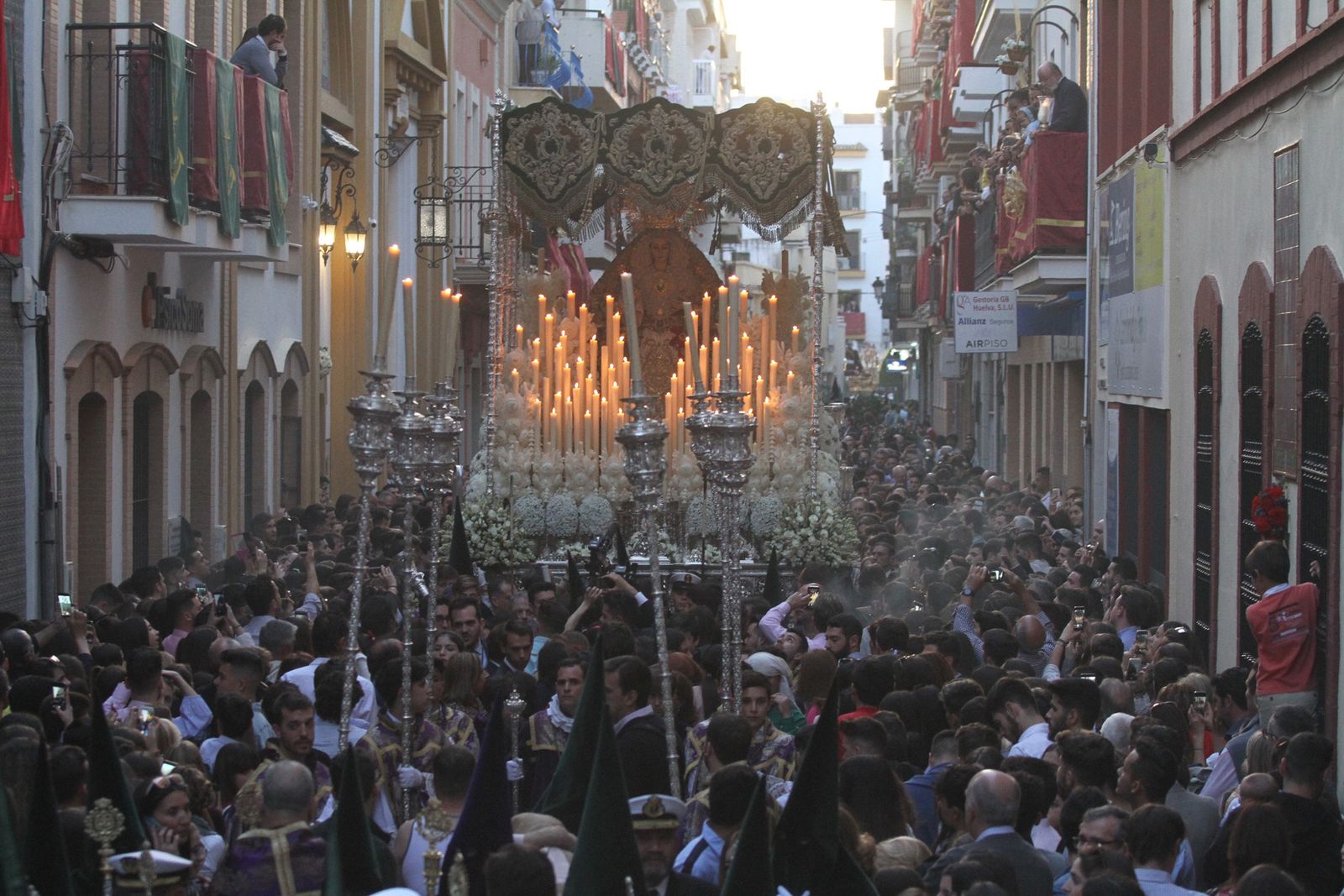 El palio de Nuestra Señora de la Esperanza Coronada camina entre la multitud en el inicio de su recorrido procesional.