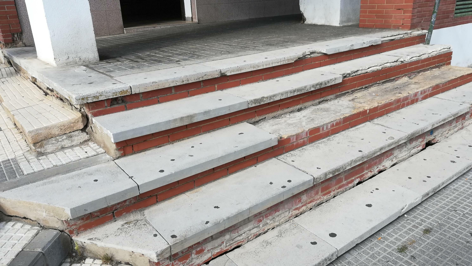 Escalones dañados entre los acerados de la barriada.