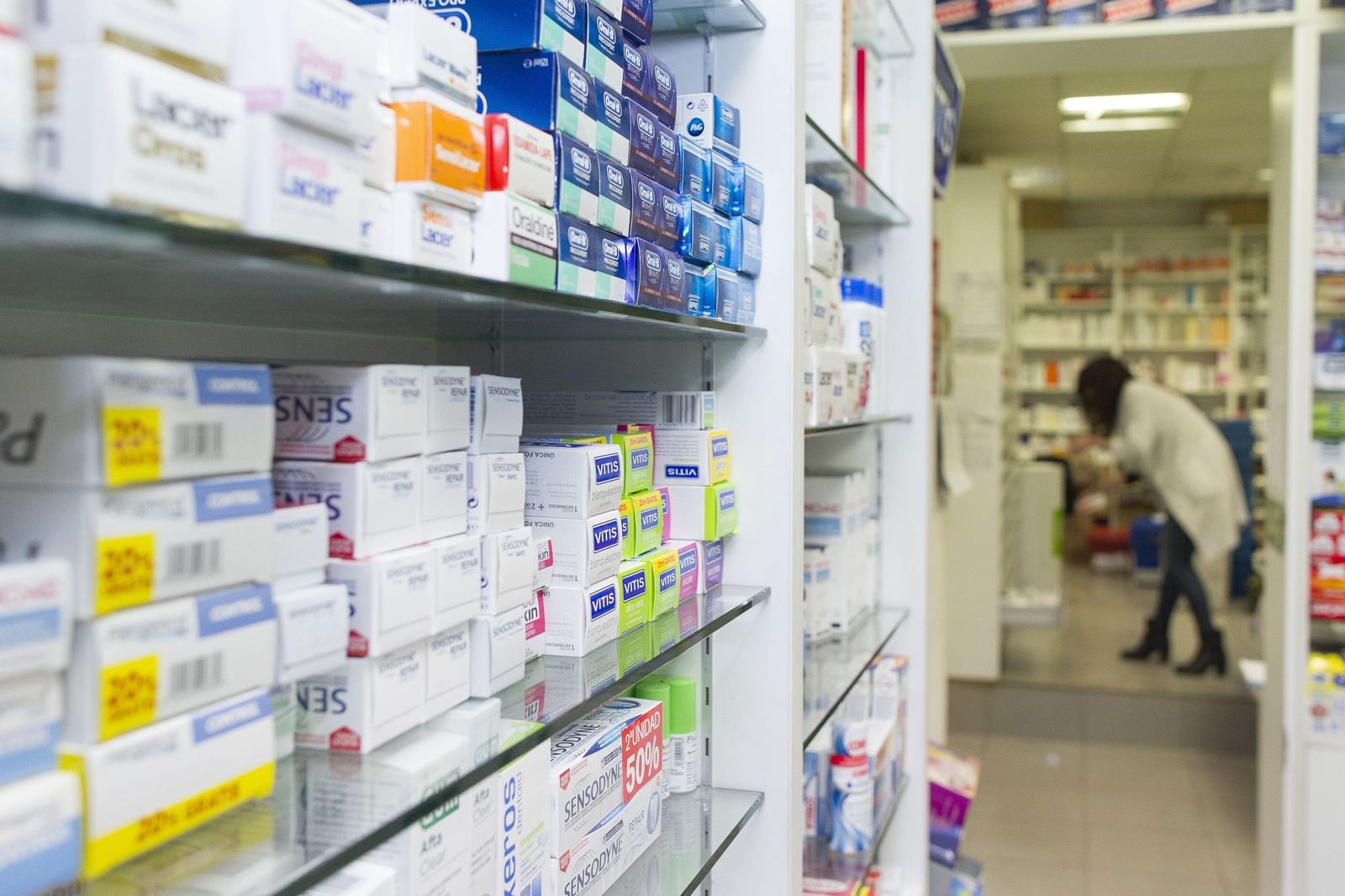 Estantería llena de medicamentos en una farmacia.