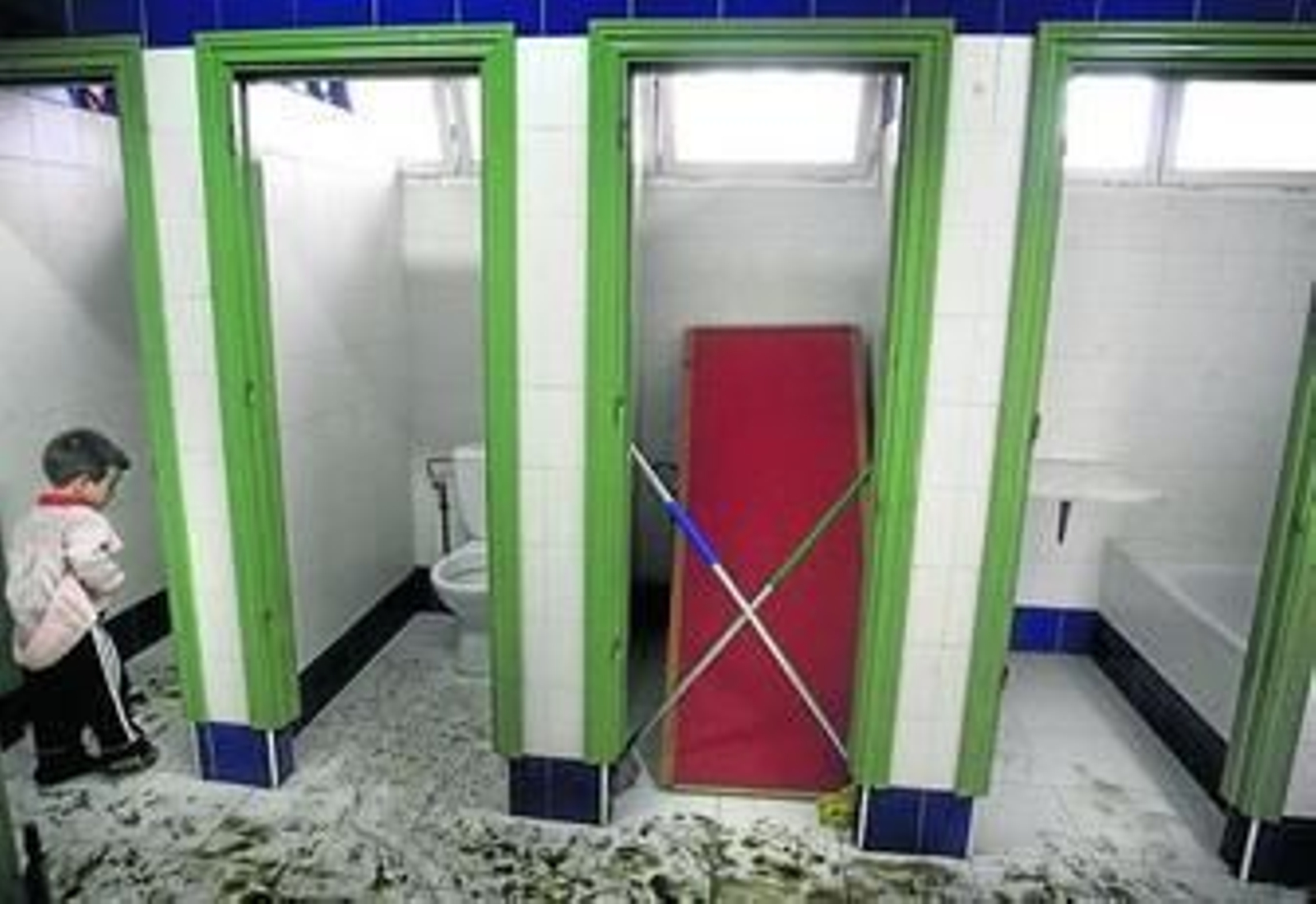 Un menor entra en los baños completamente sucios del colegio de Primaria Gibraltar.