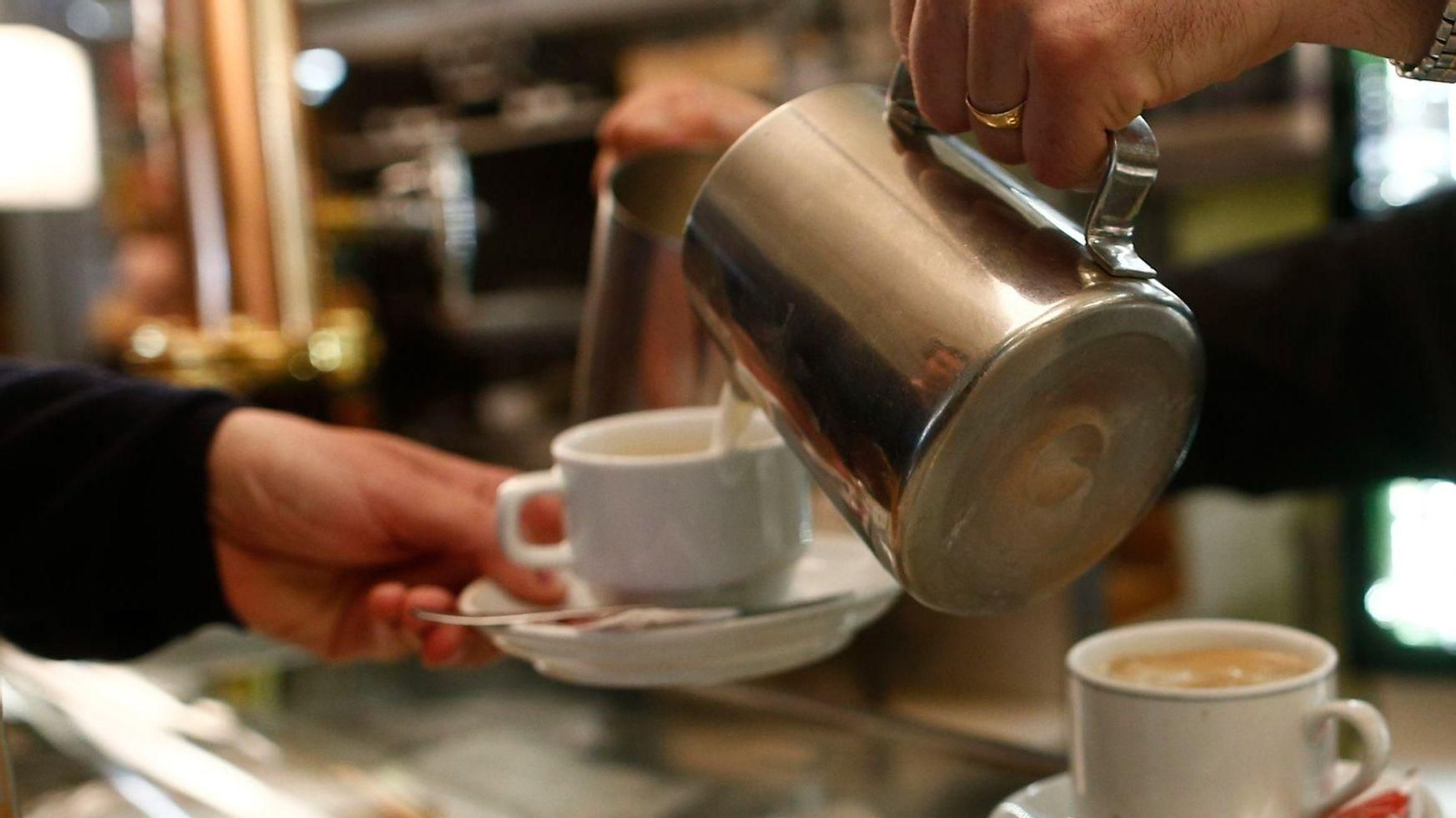 Imagen de archivo de un camarero sirviendo un café