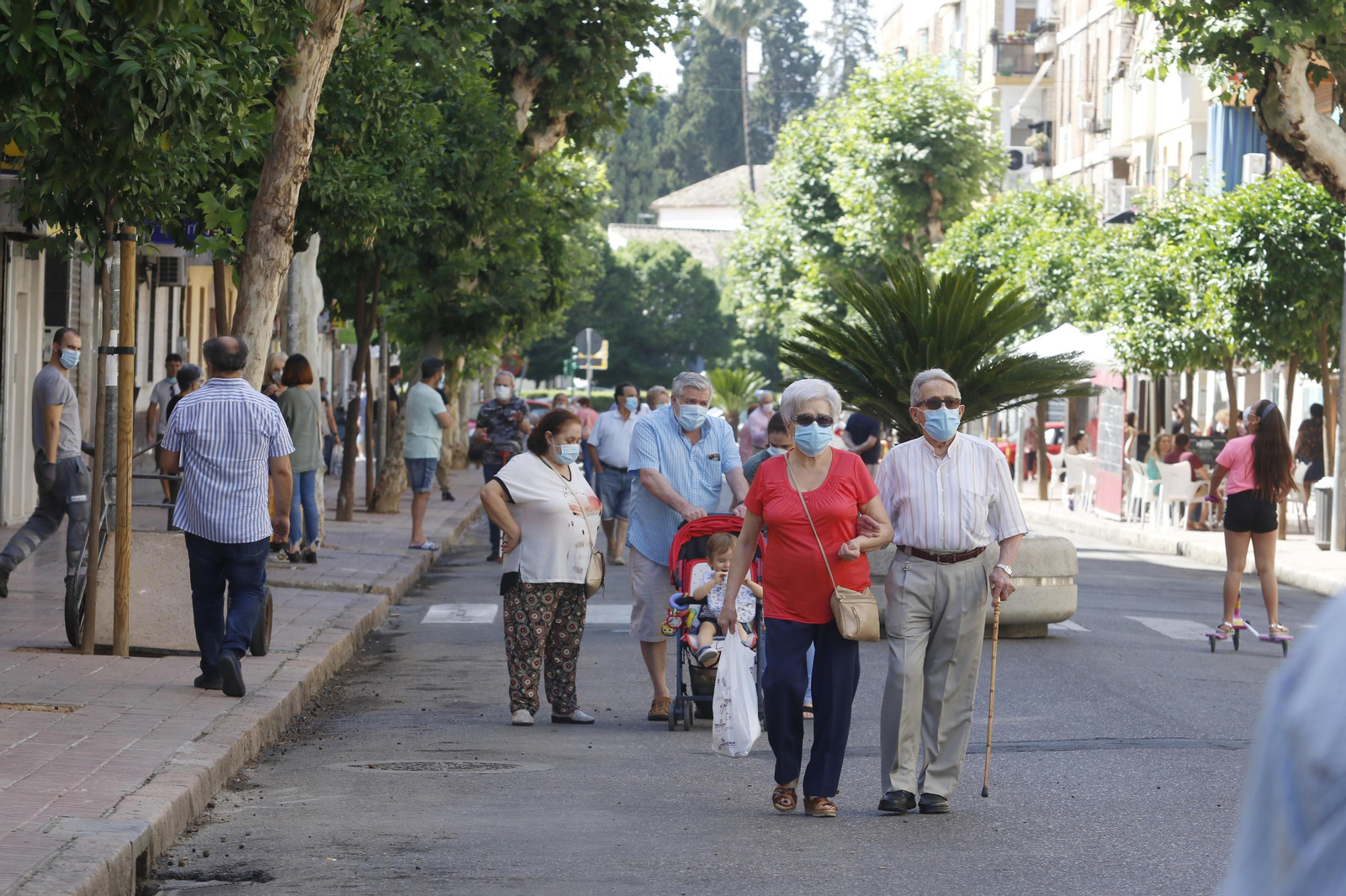 Varias personas pasean con mascarilla por la Viñuela.