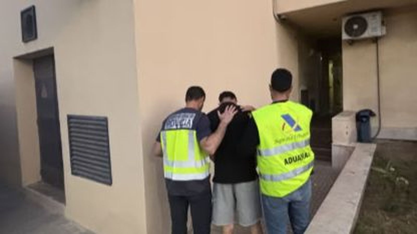 La Policía Nacional escolta a uno de los detenidos.