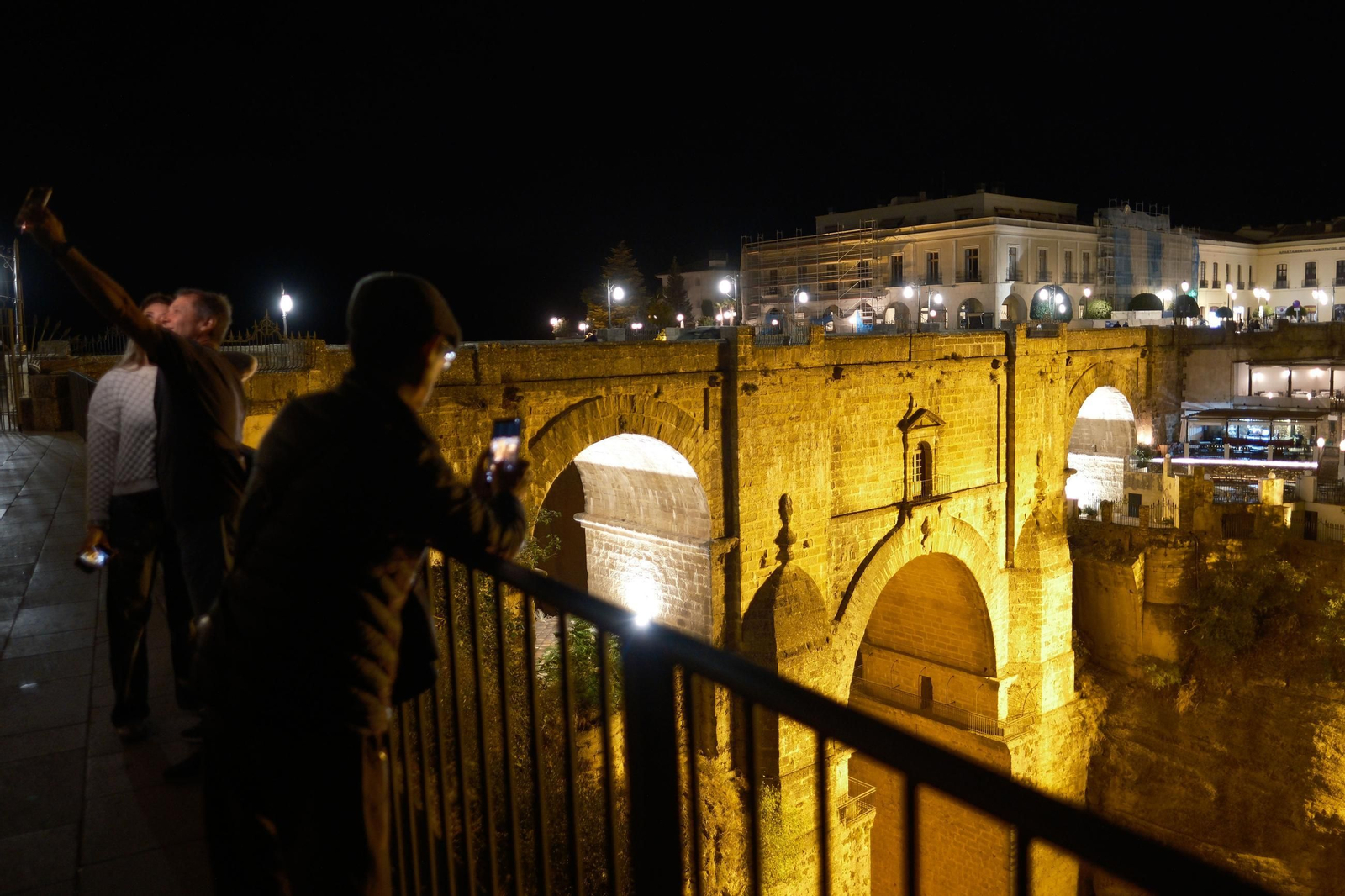 Turistas tomándose imágenes en el Puente Nuevo durante la noche. Turistas tomándose imágenes en el Puente Nuevo durante la noche.