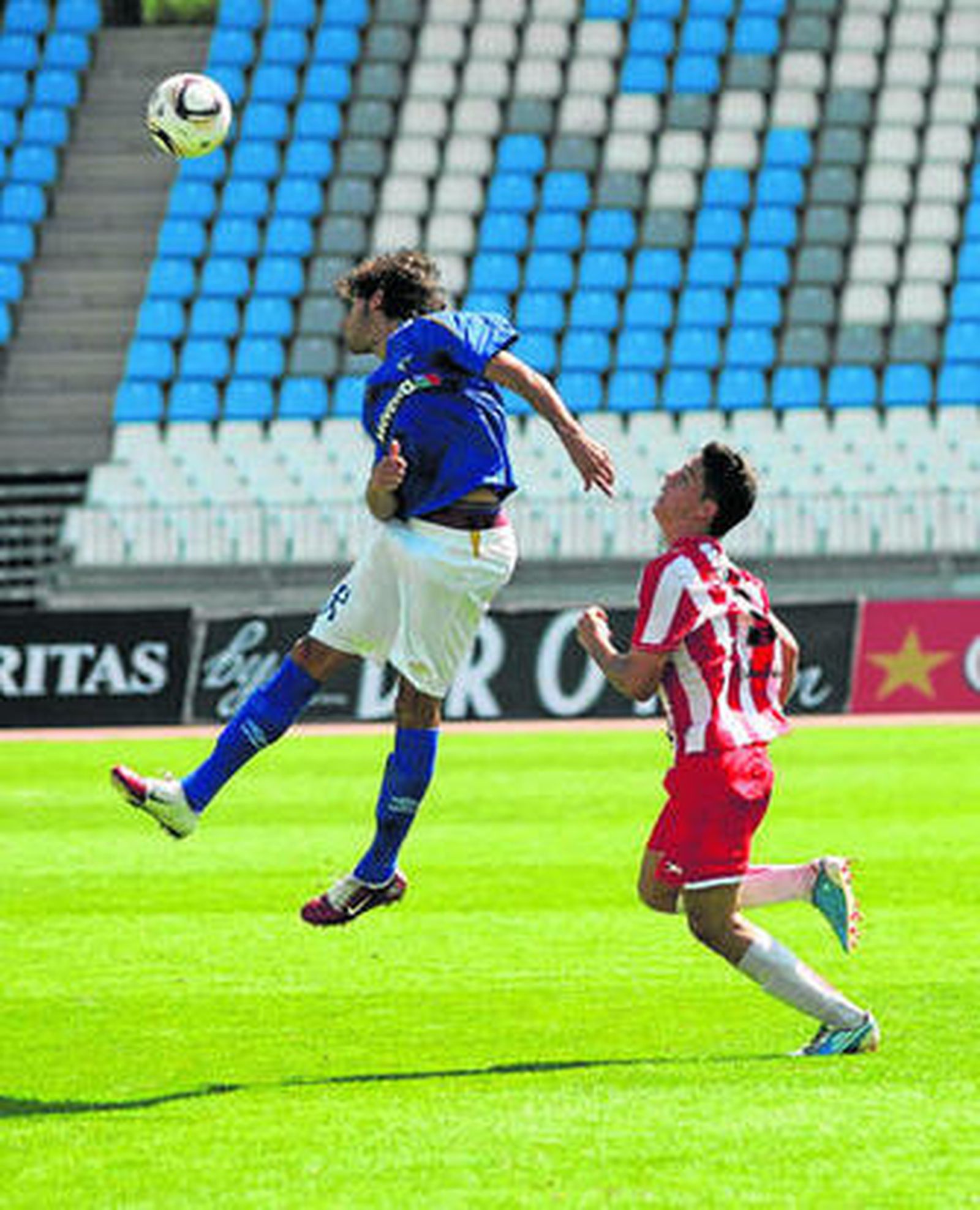 José Ramón intenta presionar a un jugador astigitano que remata un balón aéreo.