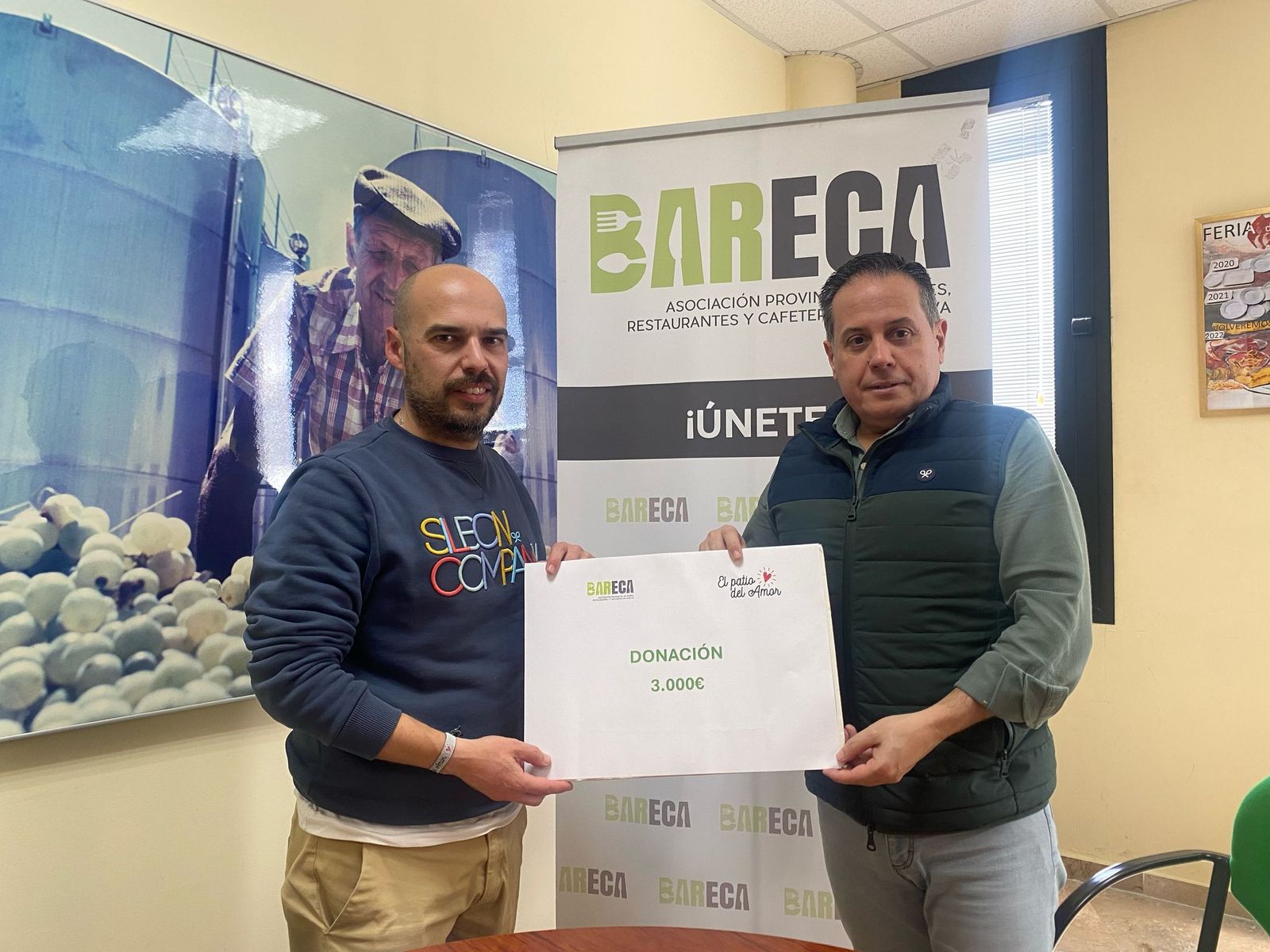 Iván Regueira (i) y Rafael Acevedo (d) con el cheque de Bareca al Patio del Amor.