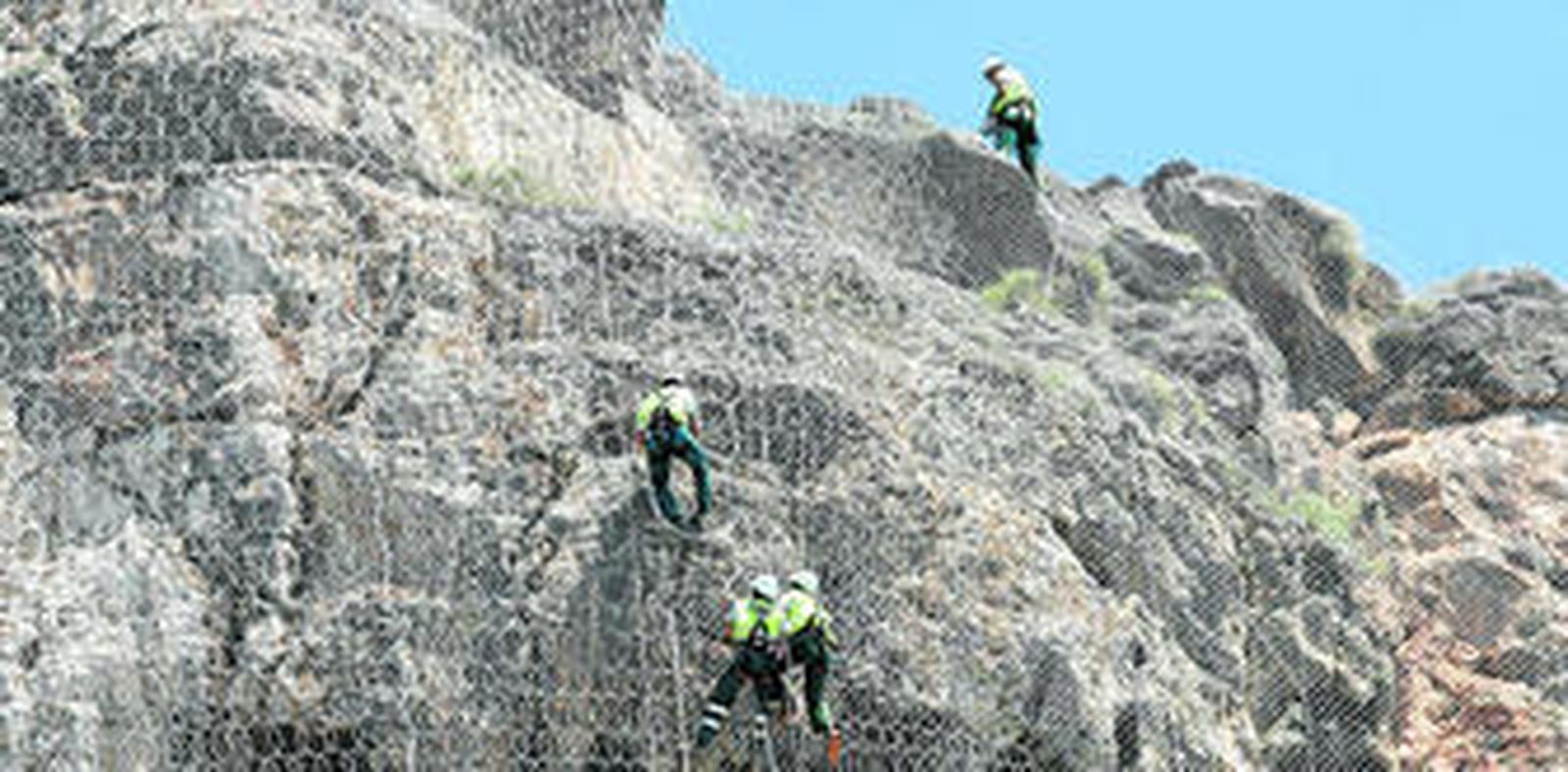 Alpinistas colgados de un 'hilo' para instalar las mallas y estabilizar taludes