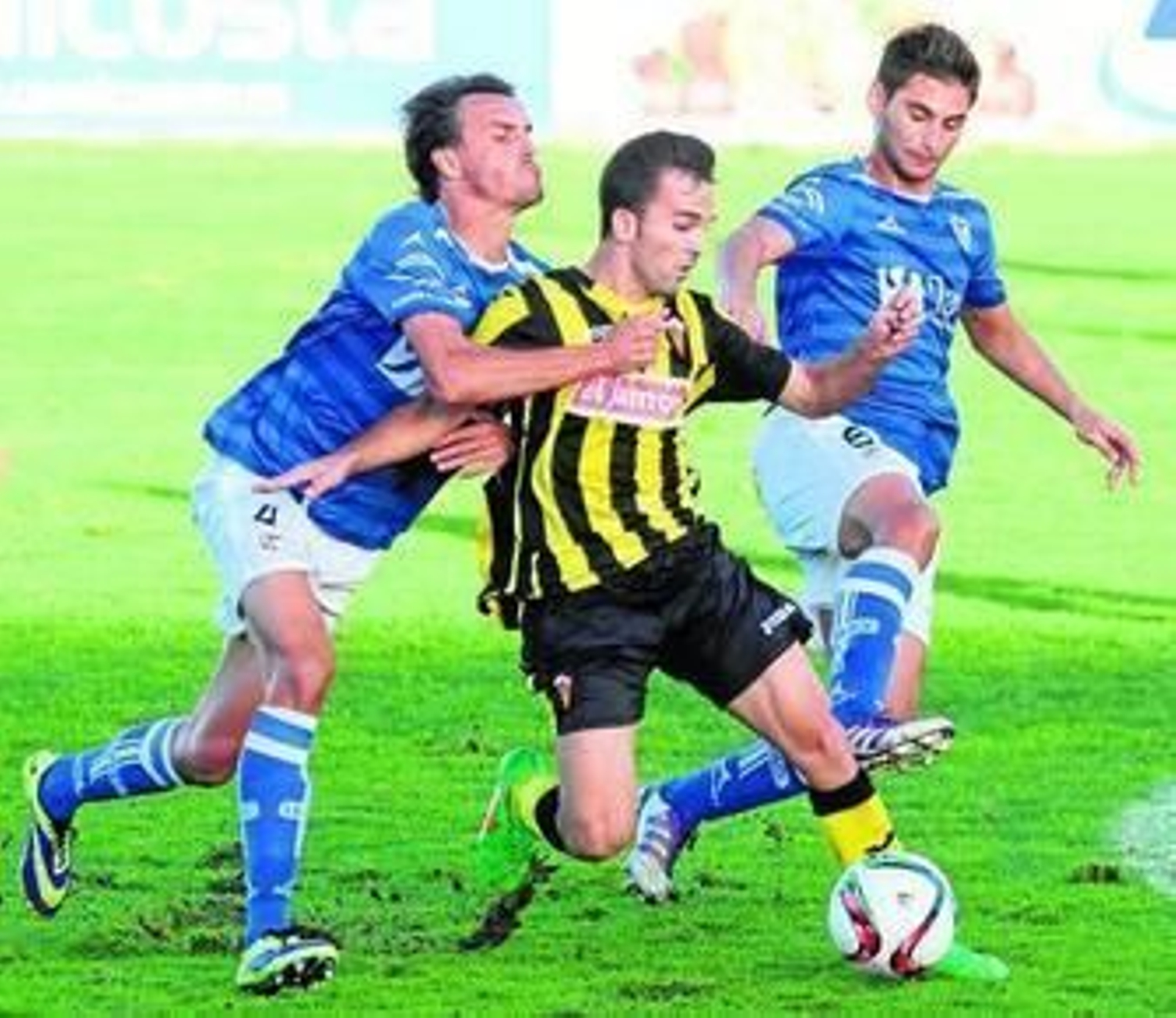 A la izquierda, Camacho es agarrado por un jugador del Linares en el duelo de ayer. A la derecha, Mena intenta robar el esférico a un futbolista del cuadro jiennense.