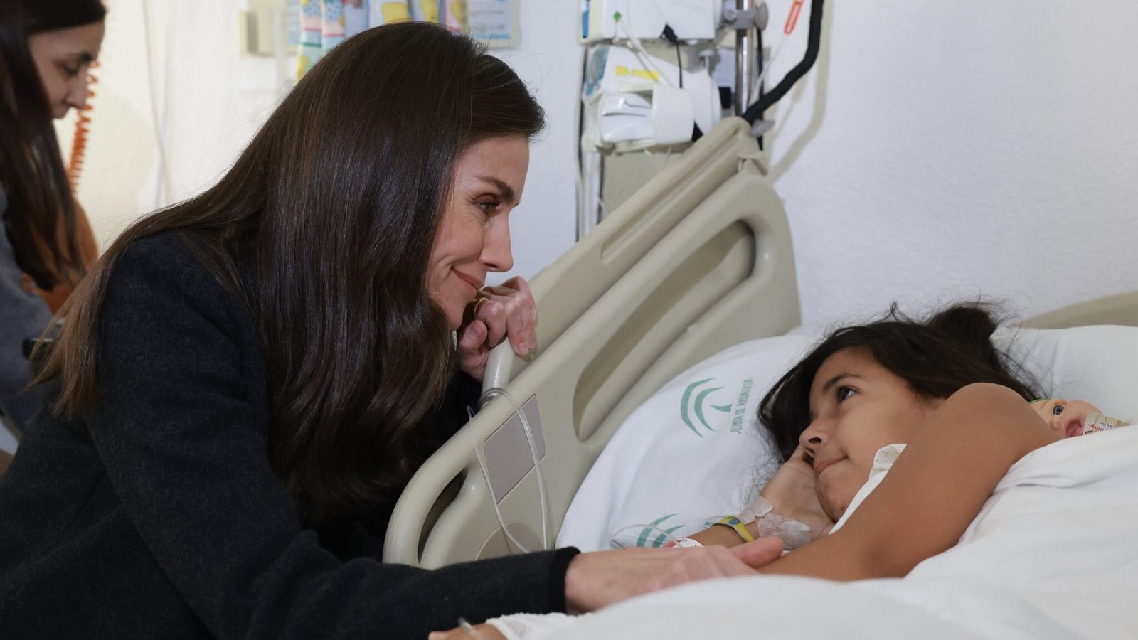 La reina Letizia charla con una de las menores hospitalizadas en el Reina Sofía.