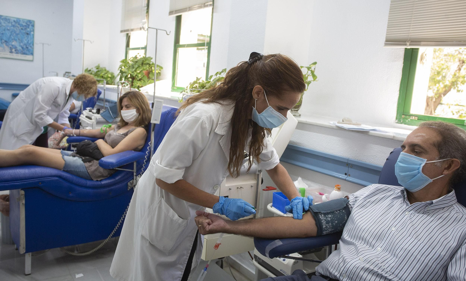 Varios donantes de sangre en el momento de la extracción en e Centro de Transfusiones Sanguíneas de Sevilla, en la calle Manuel Sirout.