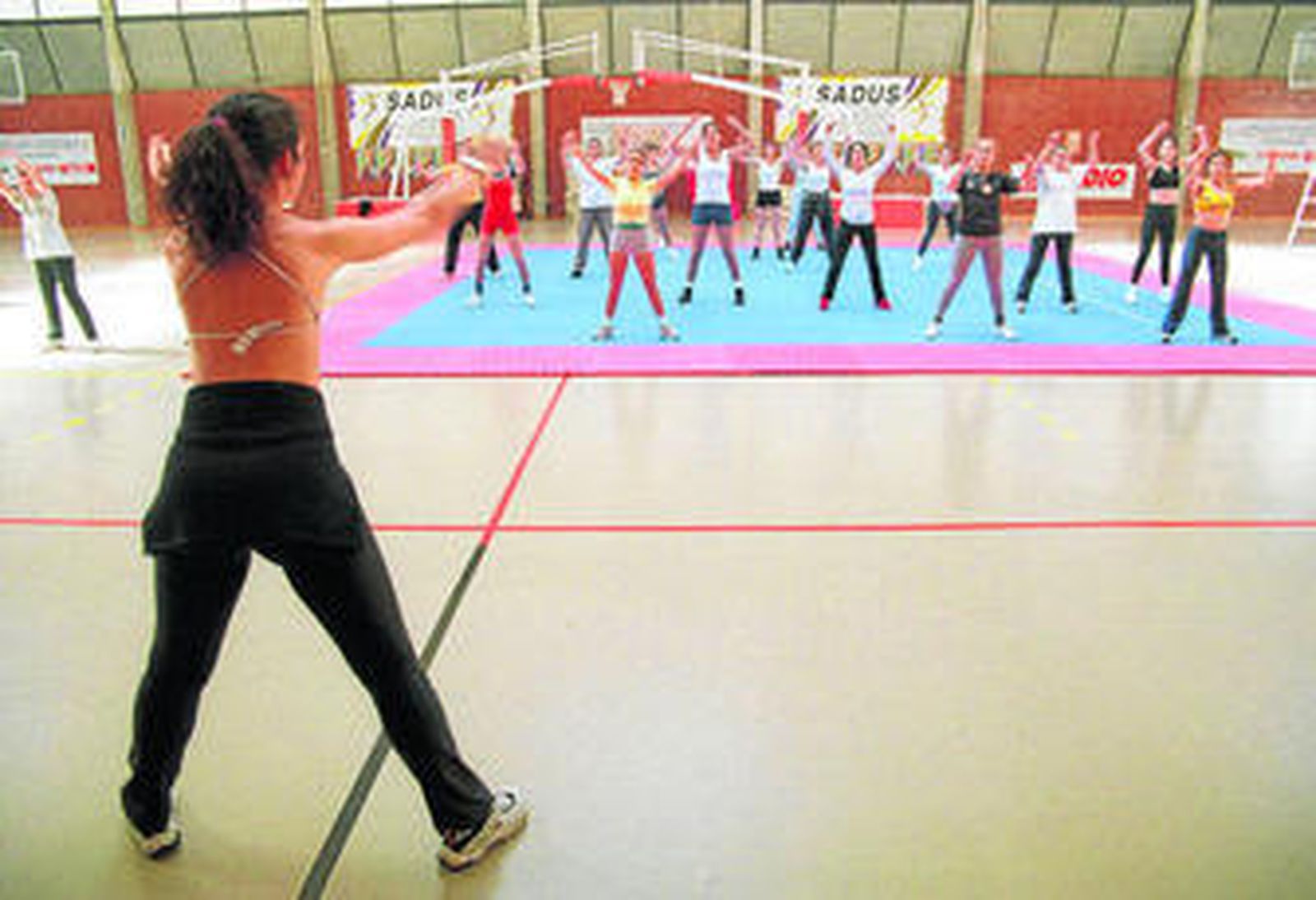 Una monitora dirige una clase de aeróbic en el pabellón deportivo de Ramón y Cajal.