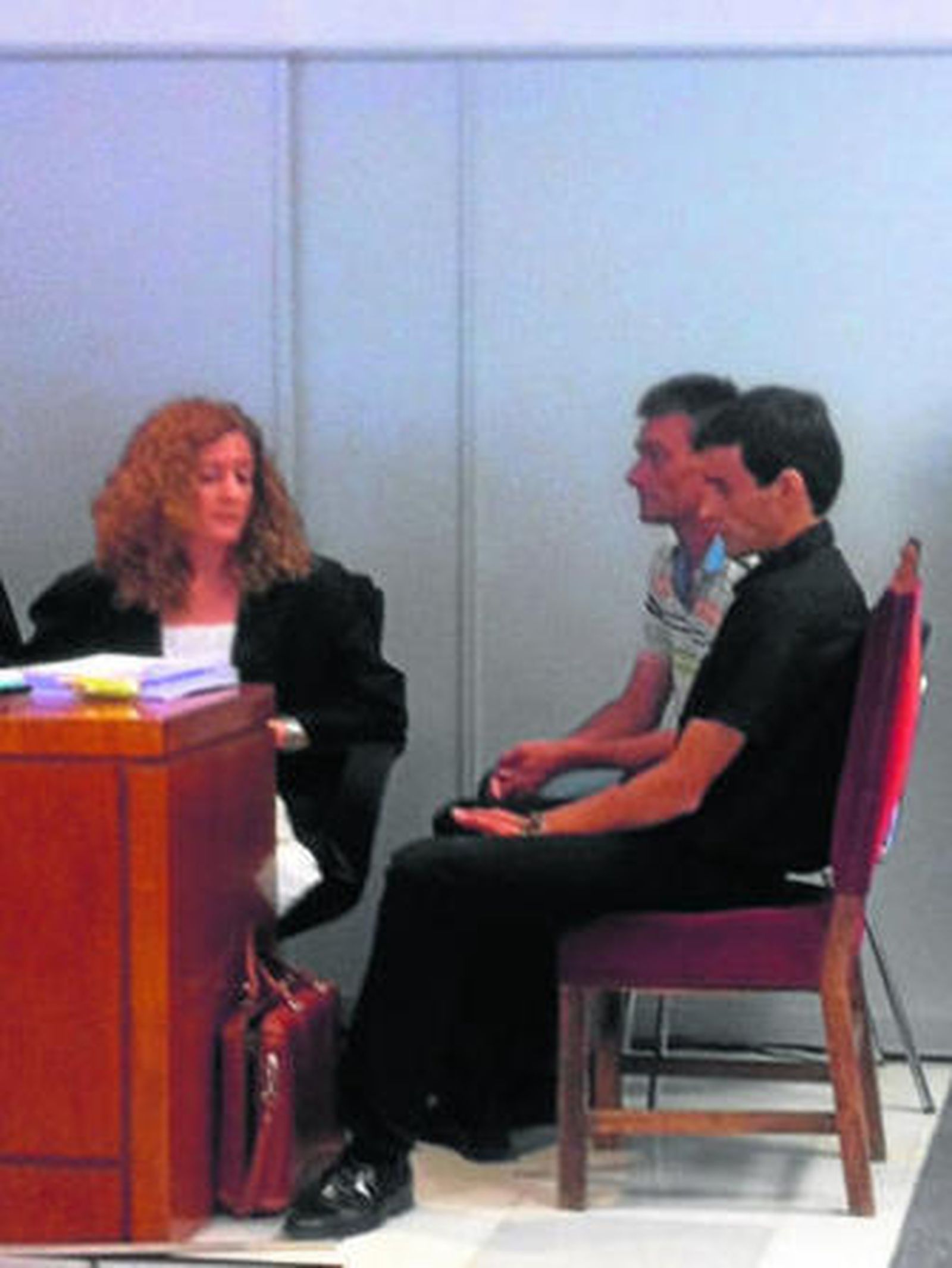 Los dos acusados junto a una de las letradas de la defensa.