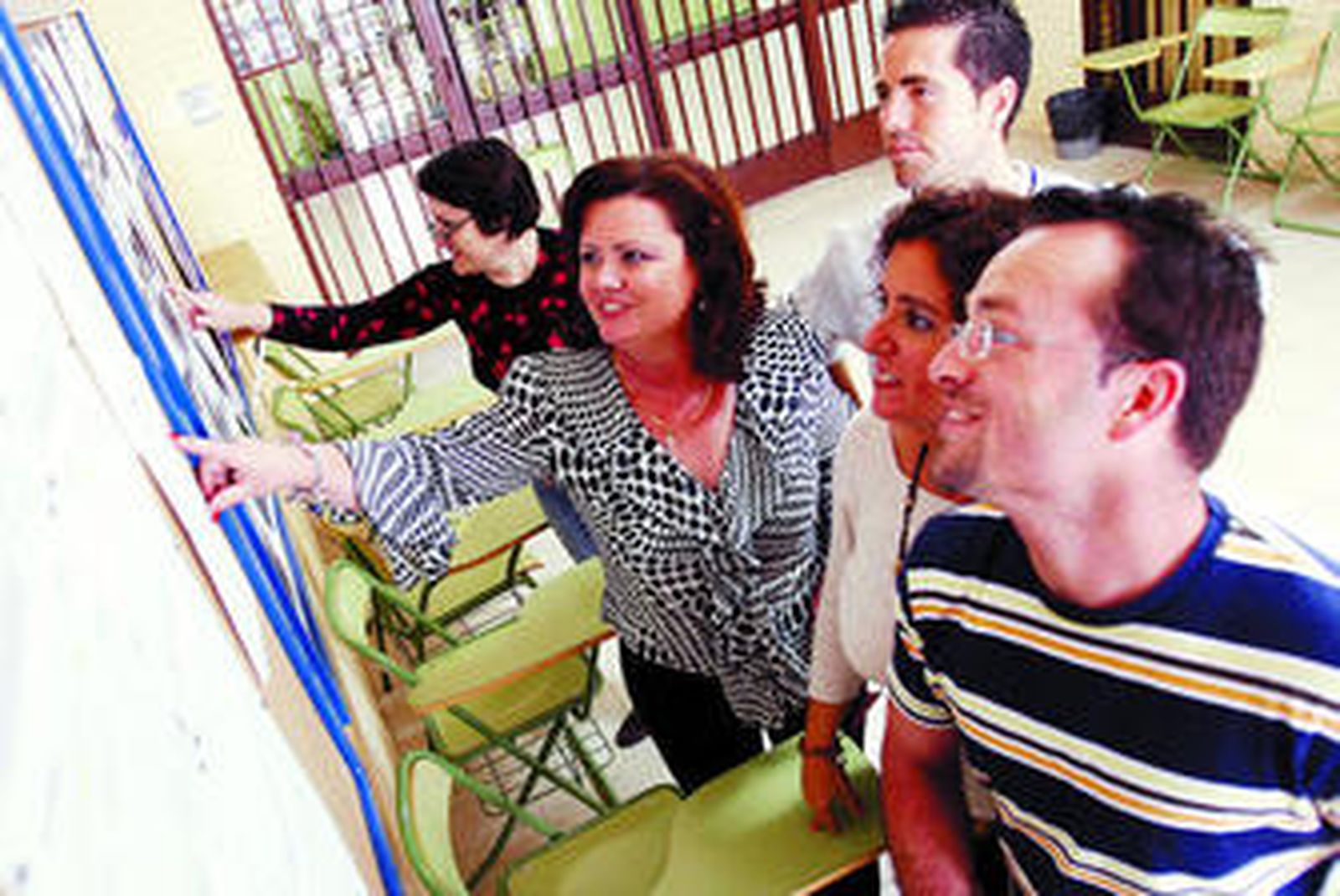 Un grupo de padres mira las listas de alumnos admitidos en un centro escolar.