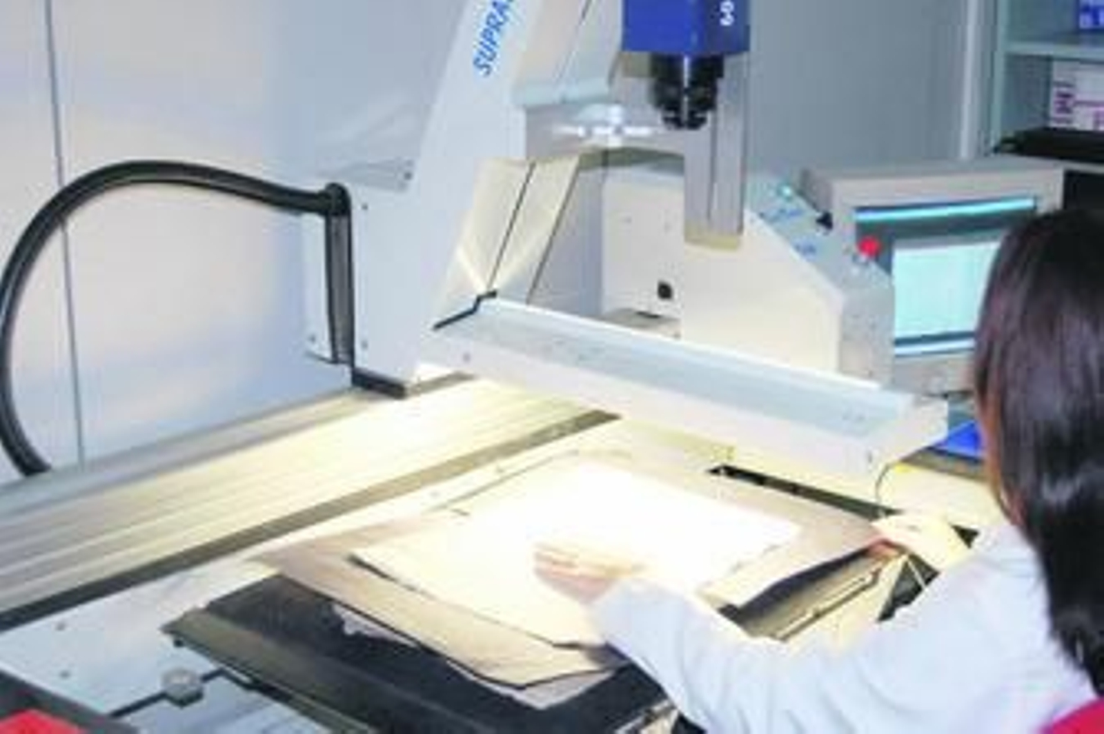 Una trabajadora digitaliza un documento.