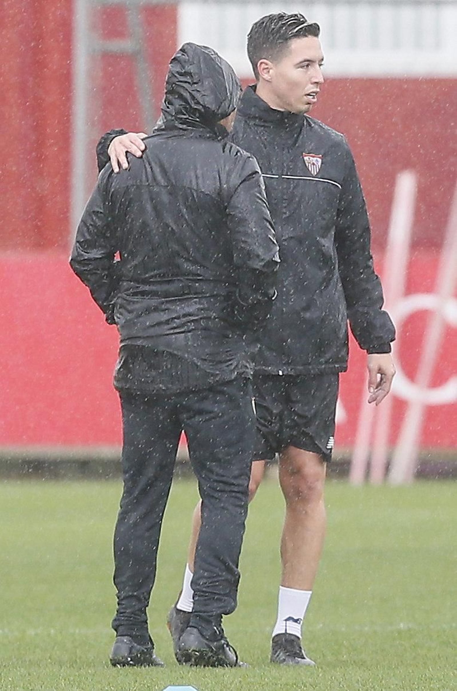 Nasri, con Sampaoli bajo la lluvia en uno de los últimos entrenamientos.