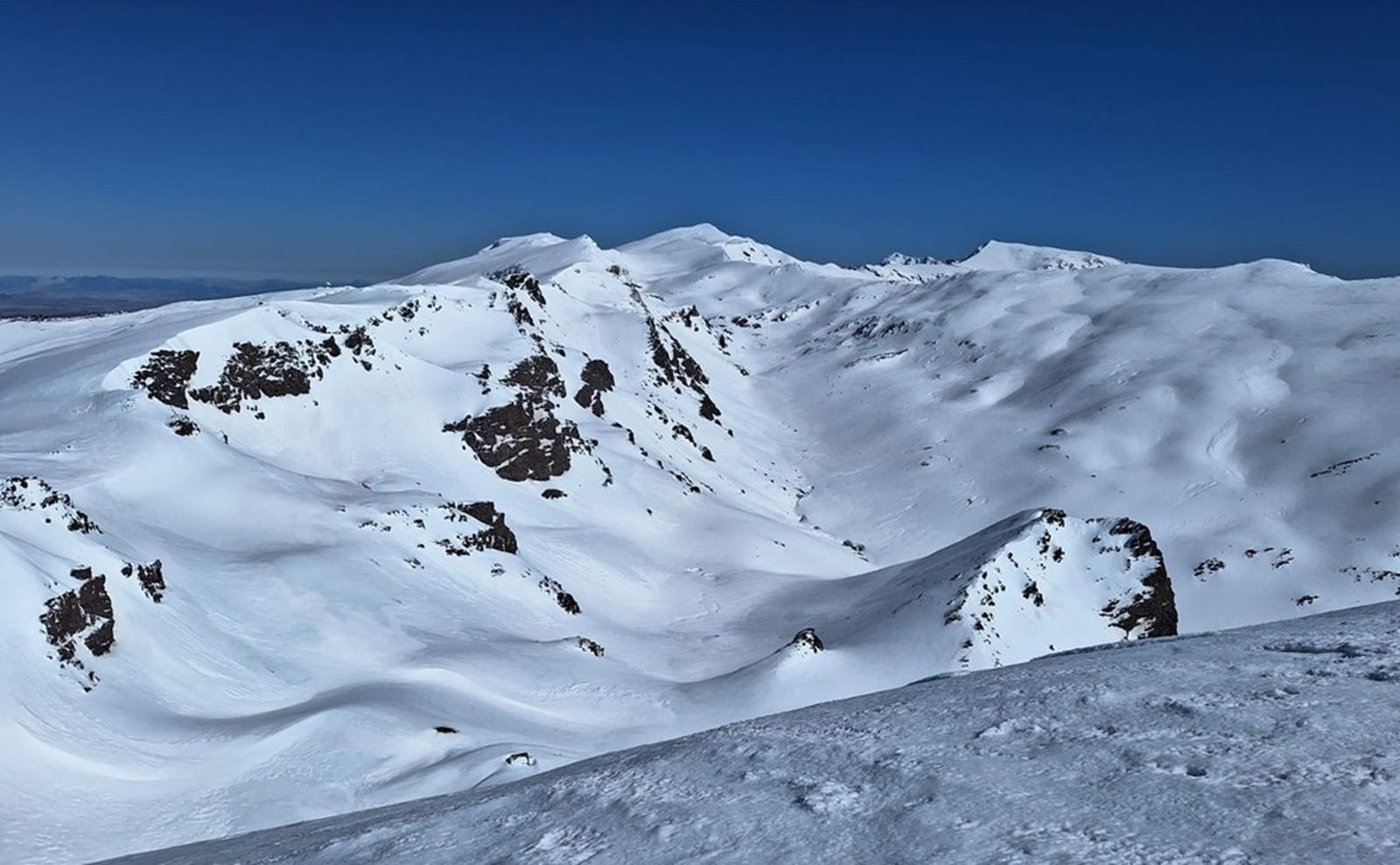 Cabecera del río Lanjarón, al fondo Veleta y Mulhacén. Paisaje suavizado por la acumulación de nieve.