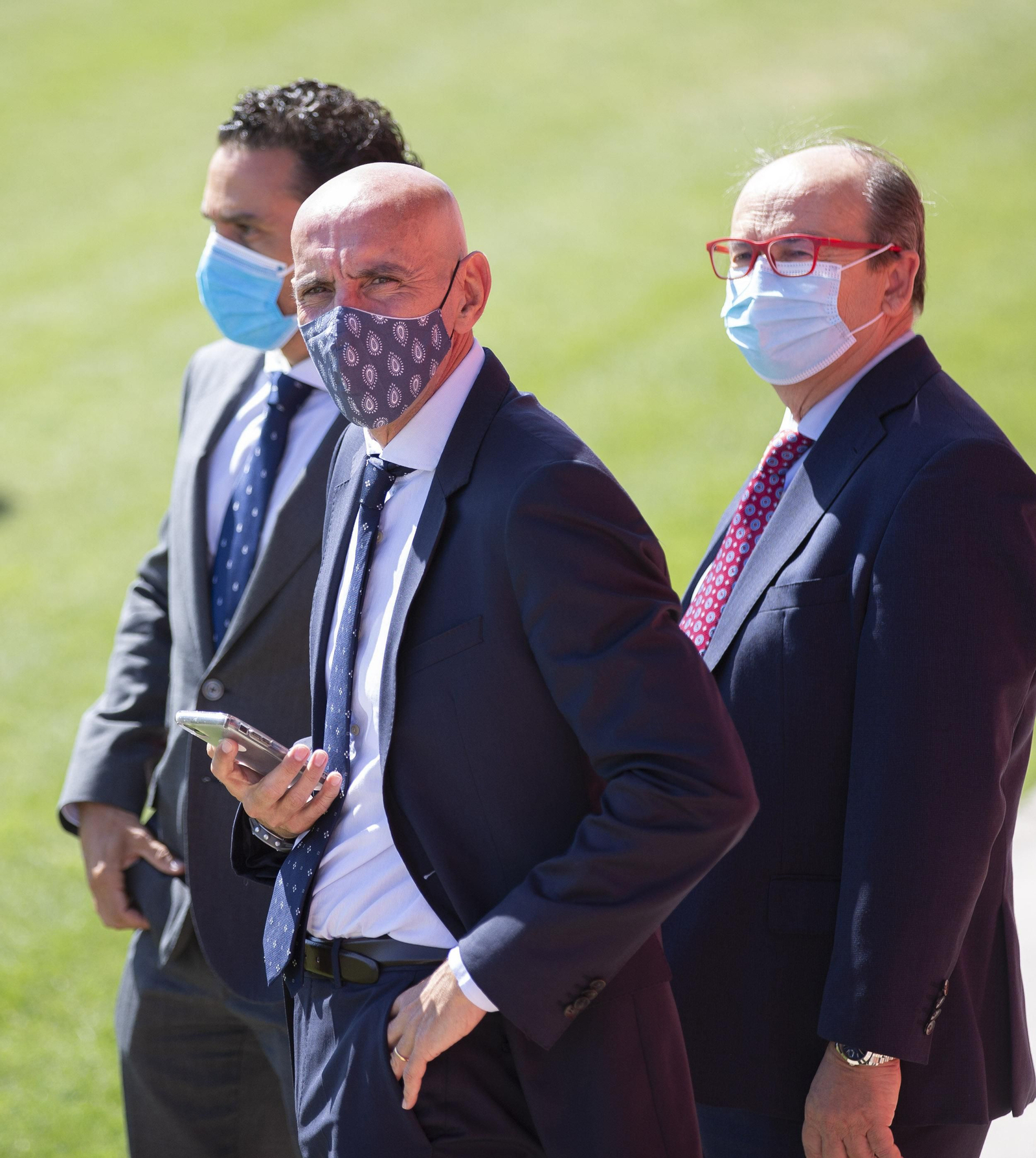 Monchi mira al fotógrafo ante Del Nido Carrasco y Castro tras la presentación de  Rakitic.